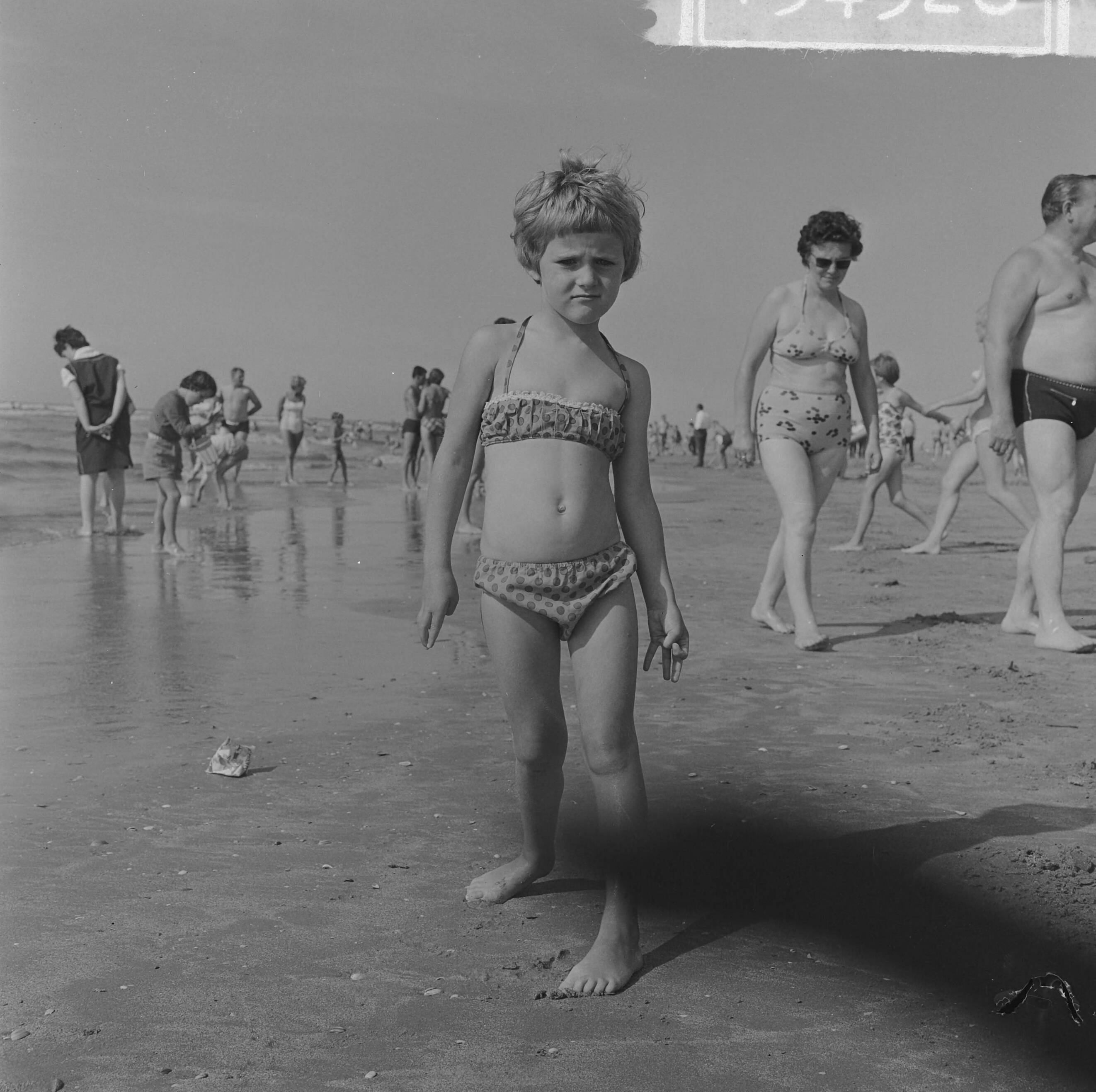 Fotocollectie Anefo — Strandmode 1963 in praktijk op het Zandvoortse strand. Klein meisje met bikini — Foto: Koch, Eric / Anefo. Licentie: Set B: Rechtenvrij / Publiek Domein. Bron: Nationaal Archief. http://hdl.handle.net/10648/aa42a6a0-d0b4-102d-bcf8-003048976d84