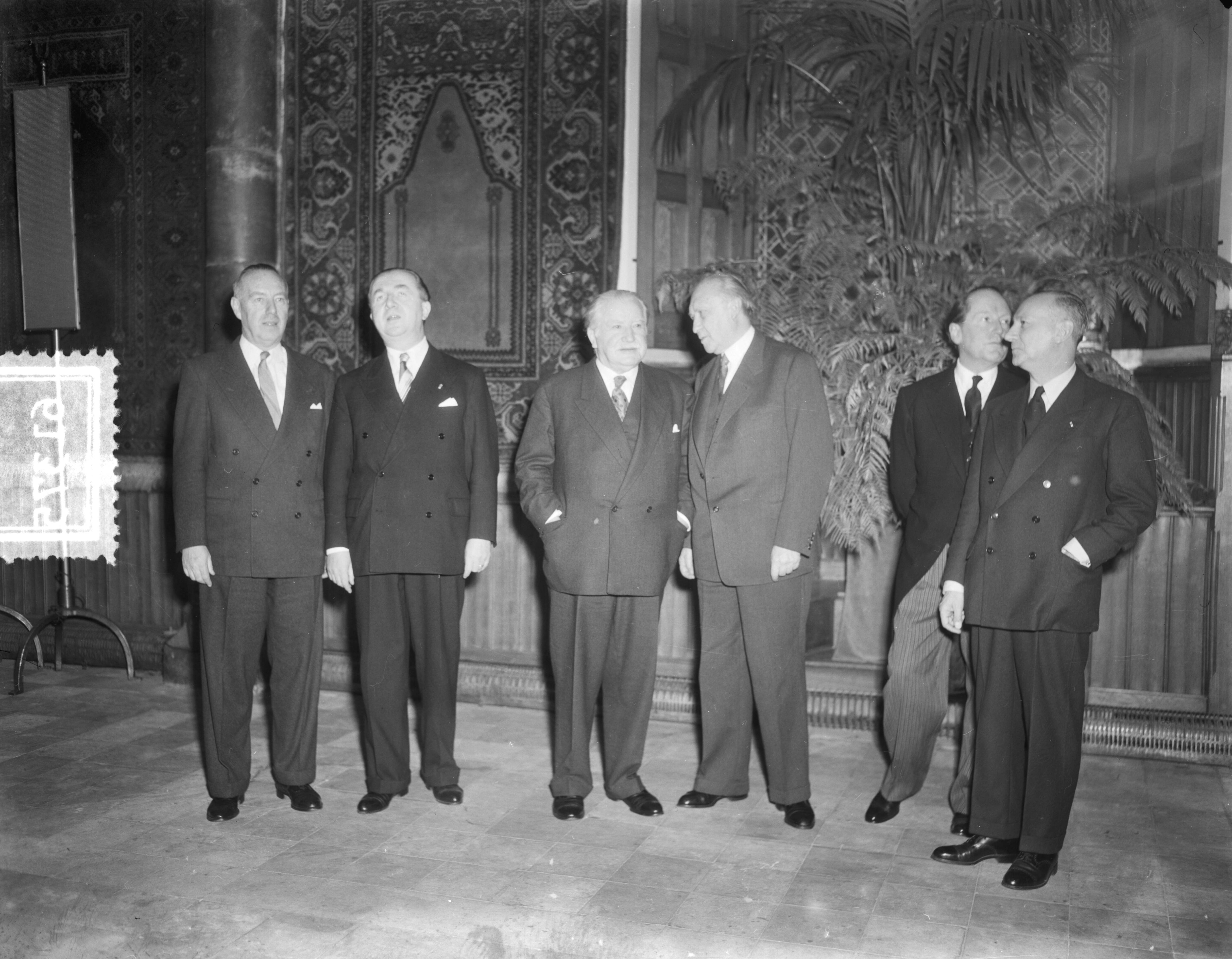 Zes landen ministersconferentie te Den Haag — Zes landen ministersconferentie te Den Haag. Vlnr. Paul van Zeeland (België, minister van Buitenlandse Zaken), Giuseppe Pella (Italië, premier), Joseph Bech (Luxemburg, minister van Buitenlandse Zaken en Wijnbouw), Konrad Adenauer (bondskanselier West-Duitsland), mr. J.W. Beyen (Nederland, minister van Buitenlandse Zaken) en Parodi (Frankrijk, secretaris-generaal Buitenlandse Zaken) — Foto: Duinen, G.W. van / Anefo. Licentie: Set B: Rechtenvrij / Publiek Domein. Bron: Nationaal Archief. http://hdl.handle.net/10648/a9184398-d0b4-102d-bcf8-003048976d84