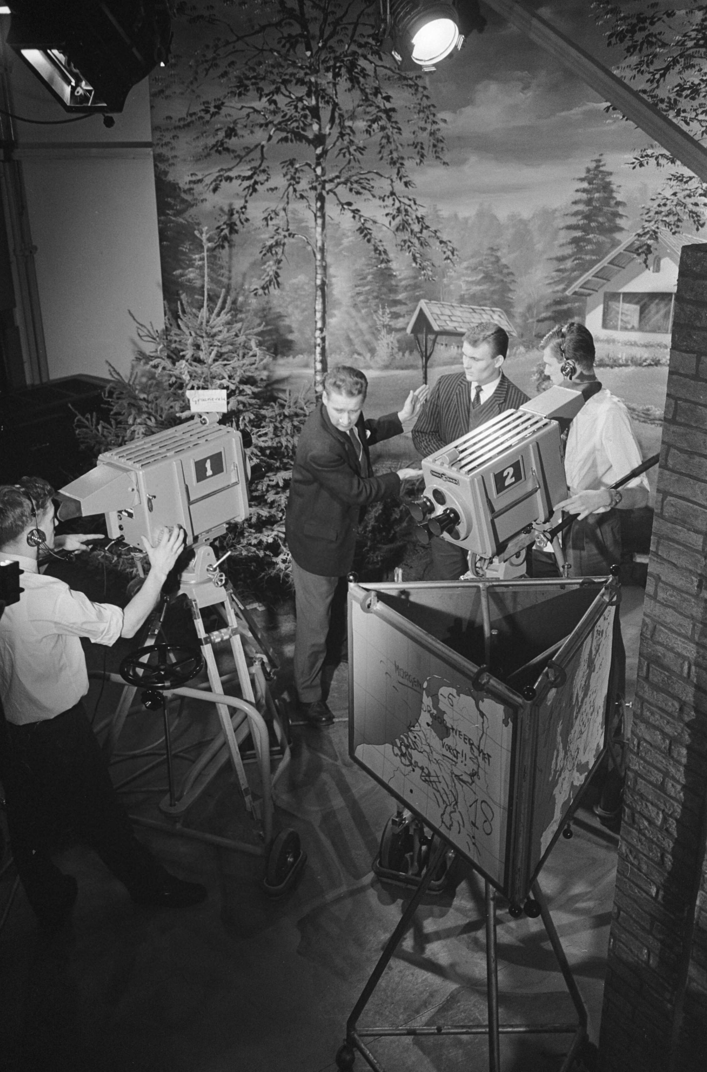 Fotocollectie Anefo — Sinds 2 januari heeft de Nederlandse Televisie Stichting (NTS) een eigen bedrijfsschool voor de opleiding tot cameraman, belichter, technicus en regisseur in kasteel Groeneveld te Baarn. In het kasteel is o.m. een kleine studio ingericht, waarin de praktijklessen worden gegeven. In het midden 1e cameraman B.G.A. van Veluwen — Foto: Rossem, Wim van / Anefo. Licentie: Set B: Rechtenvrij / Publiek Domein. Bron: Nationaal Archief. http://hdl.handle.net/10648/a9f55968-d0b4-102d-bcf8-003048976d84