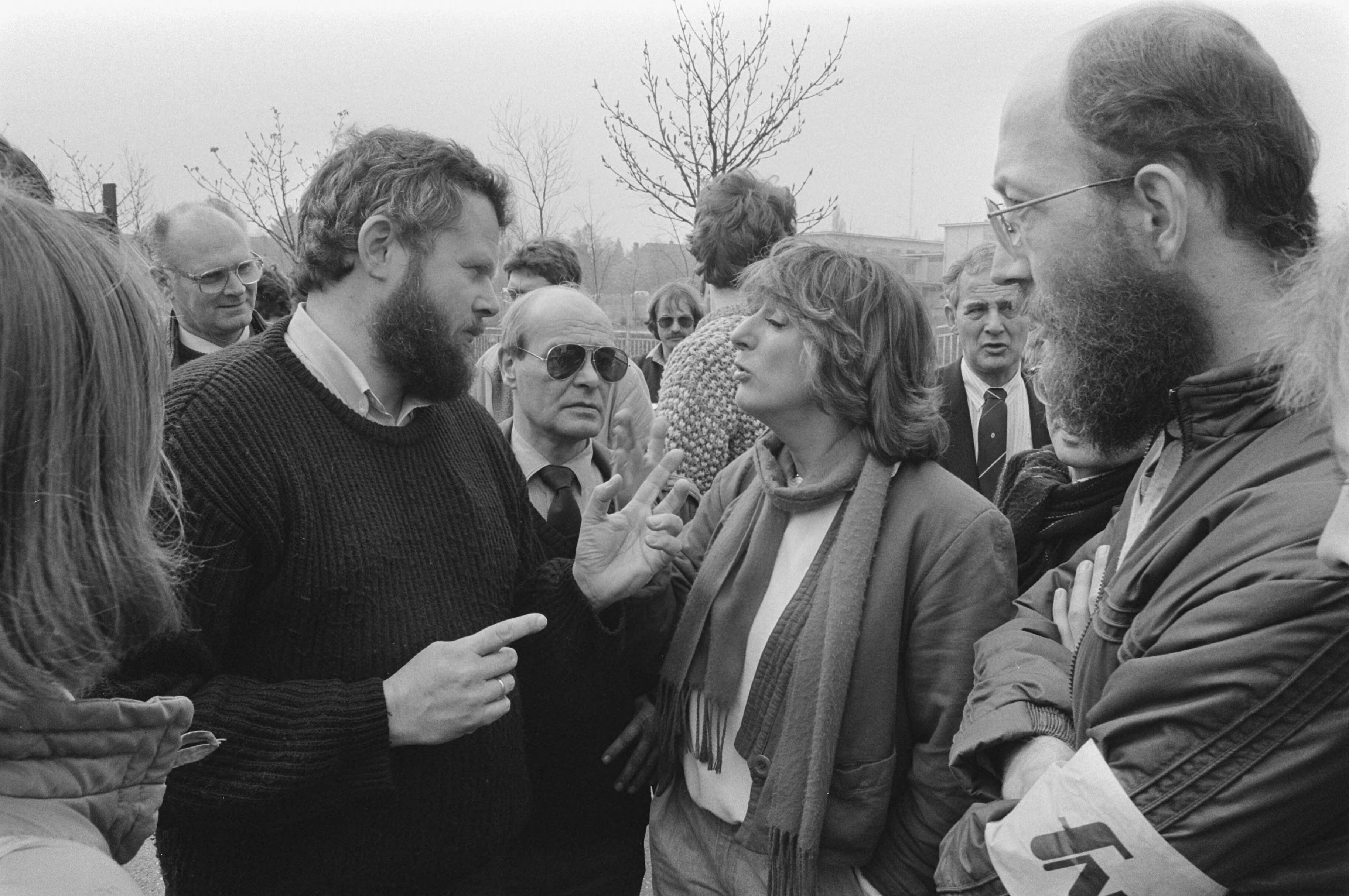 Fotocollectie Anefo — Staking omroeppersoneel tegen afwijzing omroep CAO; Postende stakers waaronder Kinderjournaalverslaggeefster Marga van Praag (midden) proberen om journaalverslaggever Hugo van Rhijn (links) te winnen voor de staking — Foto: Croes, Rob C. / Anefo. Licentie: Set B: Rechtenvrij / Publiek Domein. Bron: Nationaal Archief. http://hdl.handle.net/10648/ad457e90-d0b4-102d-bcf8-003048976d84
