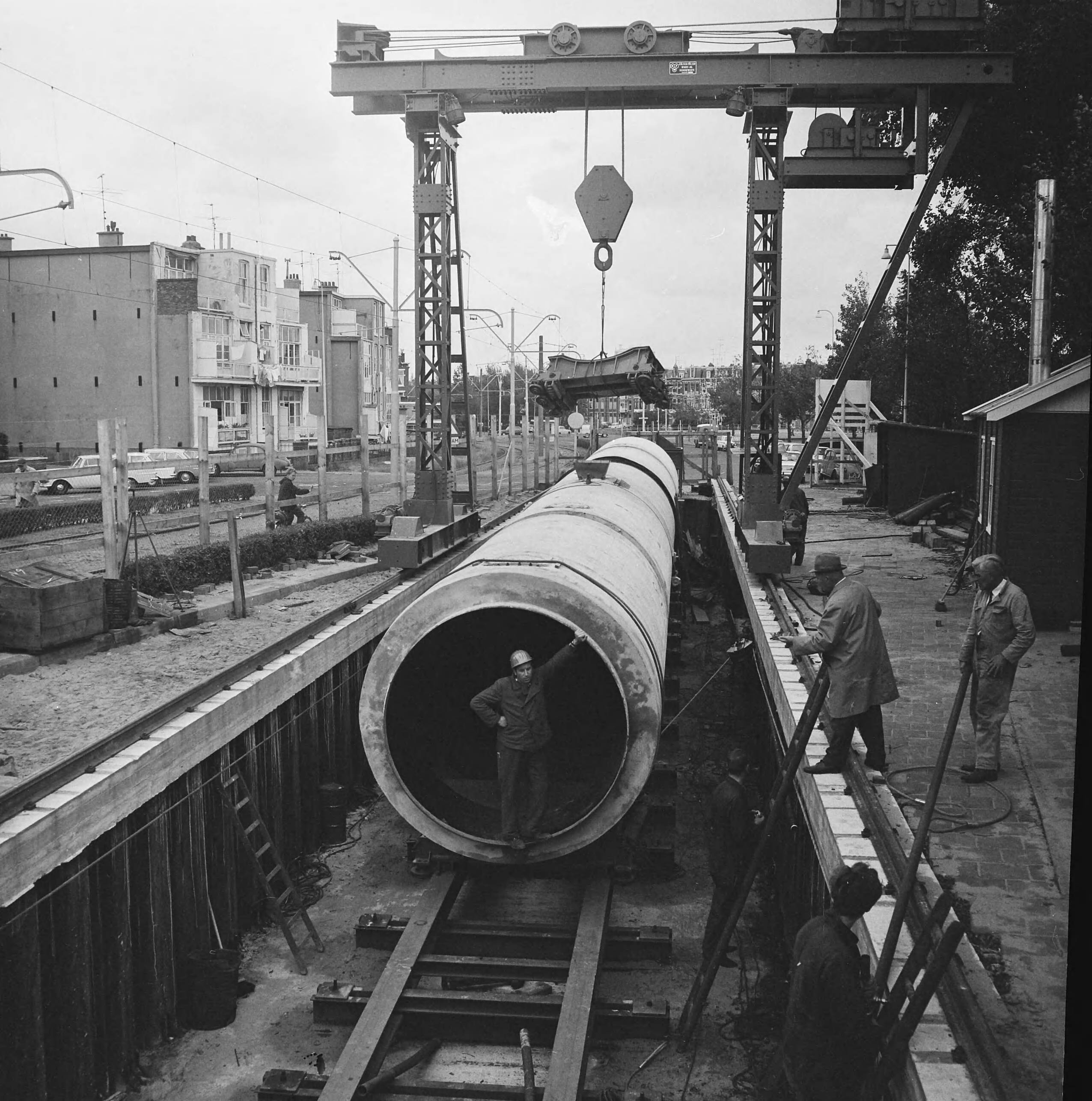 Aanleg van de afzuiginstallatie voor de riolering te Den Haag — Plaatsing van een rioolpijp — Foto: Voets, Jan / Anefo. Licentie: Set B: Rechtenvrij / Publiek Domein. Bron: Nationaal Archief. http://hdl.handle.net/10648/aafcced6-d0b4-102d-bcf8-003048976d84