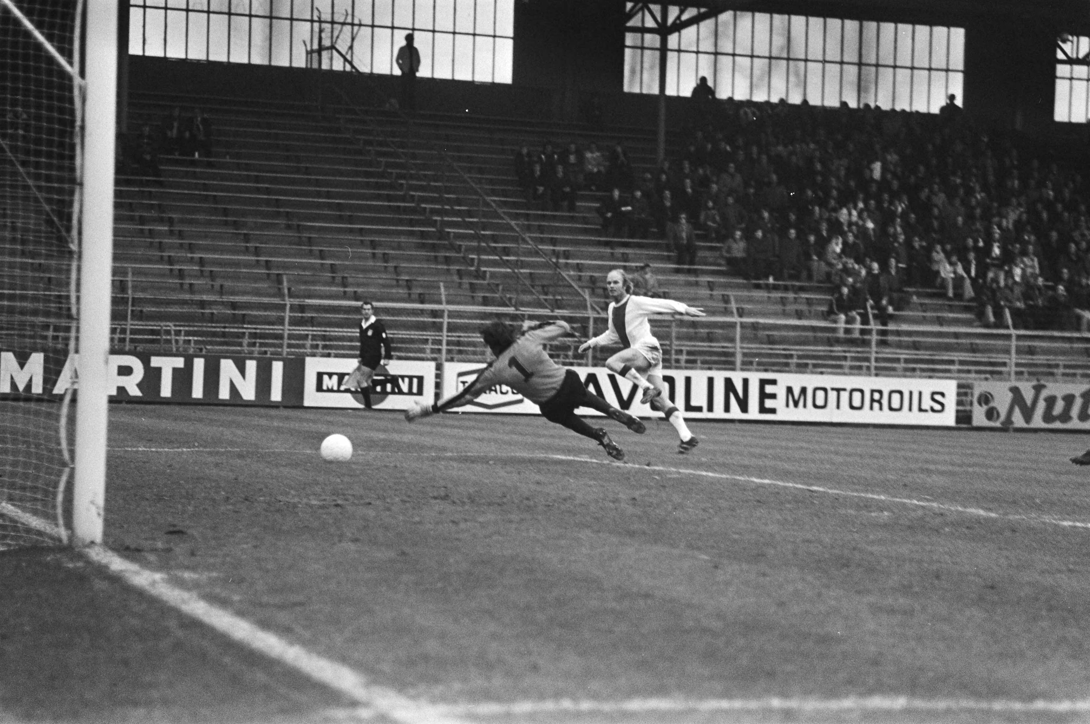 Fotocollectie Anefo — Ajax tegen Haarlem 1-1, Ruud Geels scoort langs Boersma — Foto: Bogaerts, Rob / Anefo. Licentie: Set B: Rechtenvrij / Publiek Domein. Bron: Nationaal Archief. http://hdl.handle.net/10648/aca86380-d0b4-102d-bcf8-003048976d84