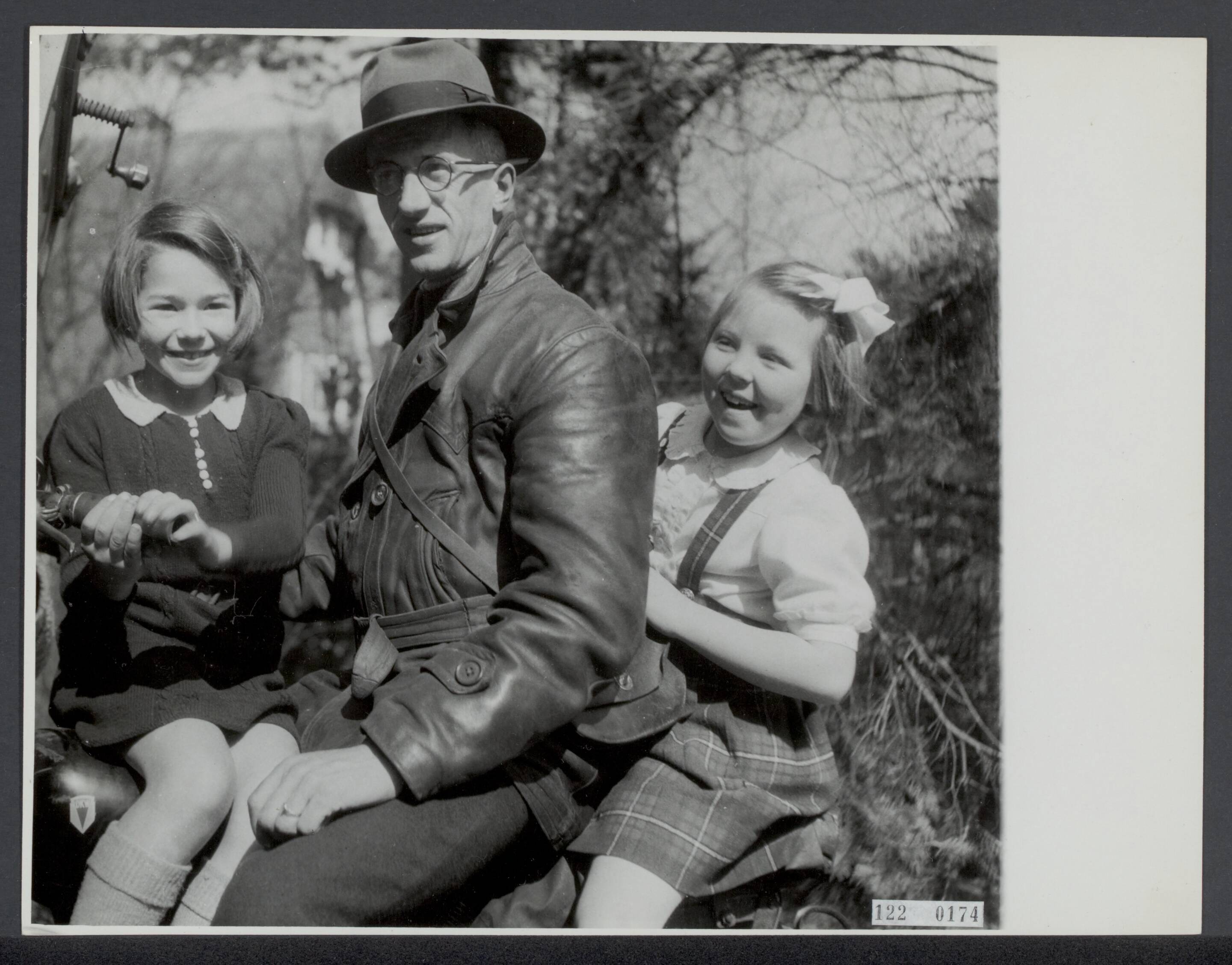 De prinsessen Beatrix en Irene op de Werkplaats Kindergemeenschap van Kees Boeke te Bilthoven — Prinses Beatrix en prinses Irene op de Werkplaats Kindergemeenschap van Kees Boeke te Bilthoven. Prinses Beatrix achter op de motorbakfiets van de bakker die brood breng — Foto: Breijer, Charles / Anefo. Licentie: Set B: Rechtenvrij / Publiek Domein. Bron: Nationaal Archief. http://hdl.handle.net/10648/af28d3c4-d0b4-102d-bcf8-003048976d84
