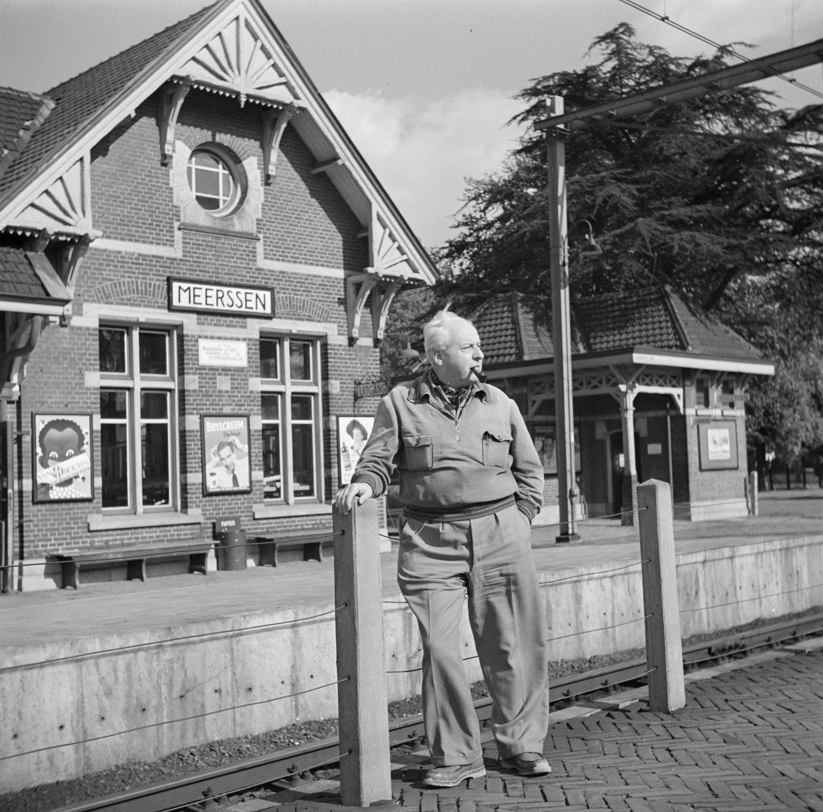 Zuid-Limburg — Willem van de Poll pijprokend op het station van Meerssen — Foto: Poll, Willem van de. Licentie: Set B: Rechtenvrij / Publiek Domein. Bron: Nationaal Archief. http://hdl.handle.net/10648/aea62262-d0b4-102d-bcf8-003048976d84