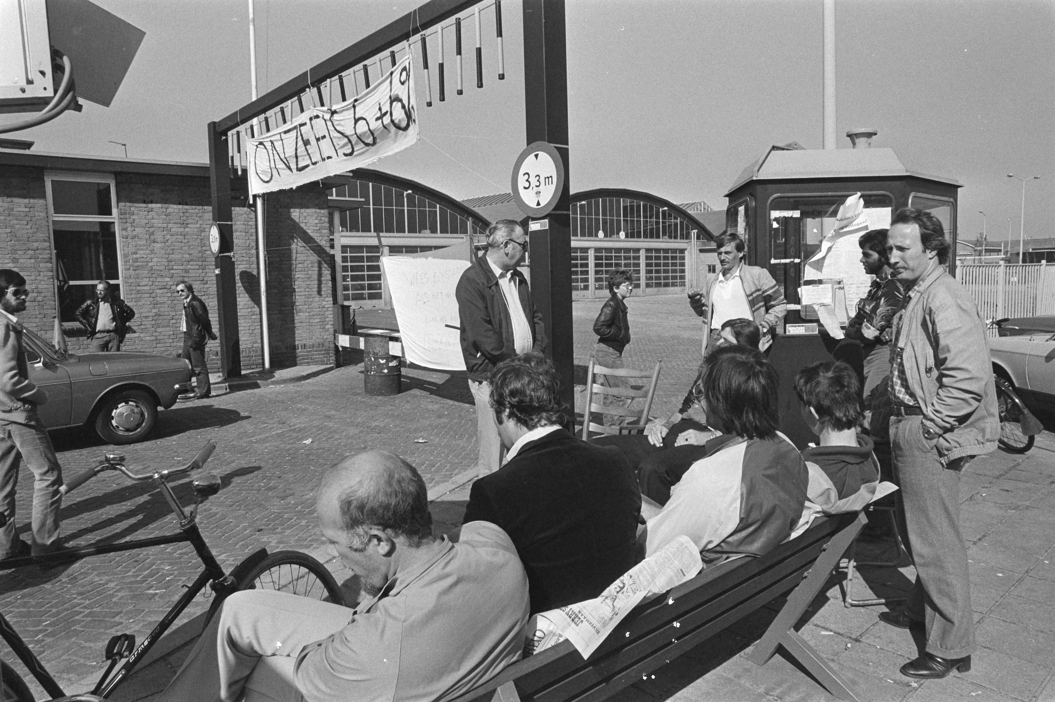 Fotocollectie Anefo — Staking HTM in Den Haag duurt voort, stakende buschauffeur zittend in de zon voor de garage — Foto: Dijk, Hans van / Anefo. Licentie: Set B: Rechtenvrij / Publiek Domein. Bron: Nationaal Archief. http://hdl.handle.net/10648/acfbeafa-d0b4-102d-bcf8-003048976d84