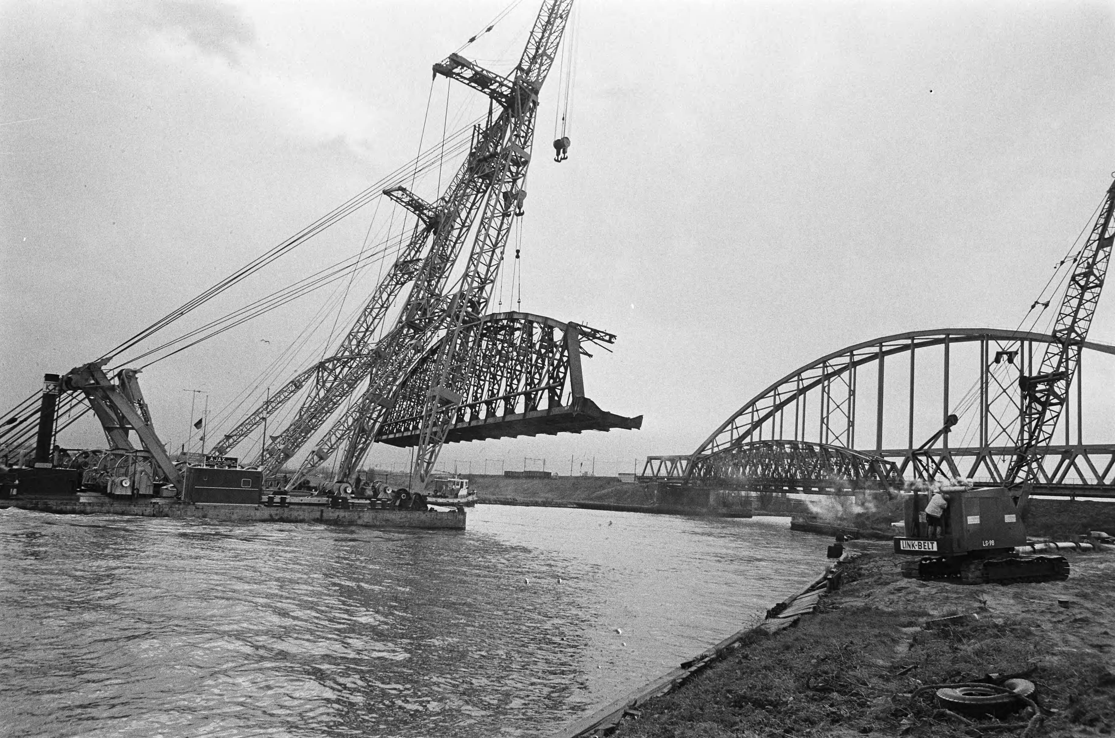 Oude spoorbrug over het Amsterdam -Rijnkanaal wordt opgeruimd — Een overzichtvan de werkzaamheden — Foto: Fotograaf Onbekend / Anefo. Licentie: Set B: Rechtenvrij / Publiek Domein. Bron: Nationaal Archief. http://hdl.handle.net/10648/ac3d61d4-d0b4-102d-bcf8-003048976d84