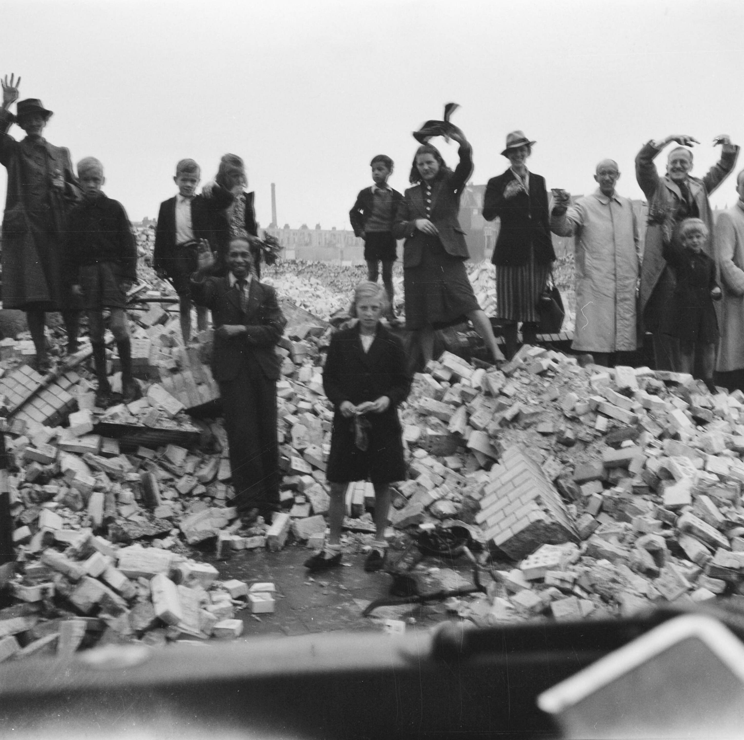 Koningin Wilhelmina terug in Den Haag — Zwaaiend publiek staande op puinhopen — Foto: Meijboom, Marius / Anefo. Licentie: Set B: Rechtenvrij / Publiek Domein. Bron: Nationaal Archief. http://hdl.handle.net/10648/ac0f0df2-d0b4-102d-bcf8-003048976d84