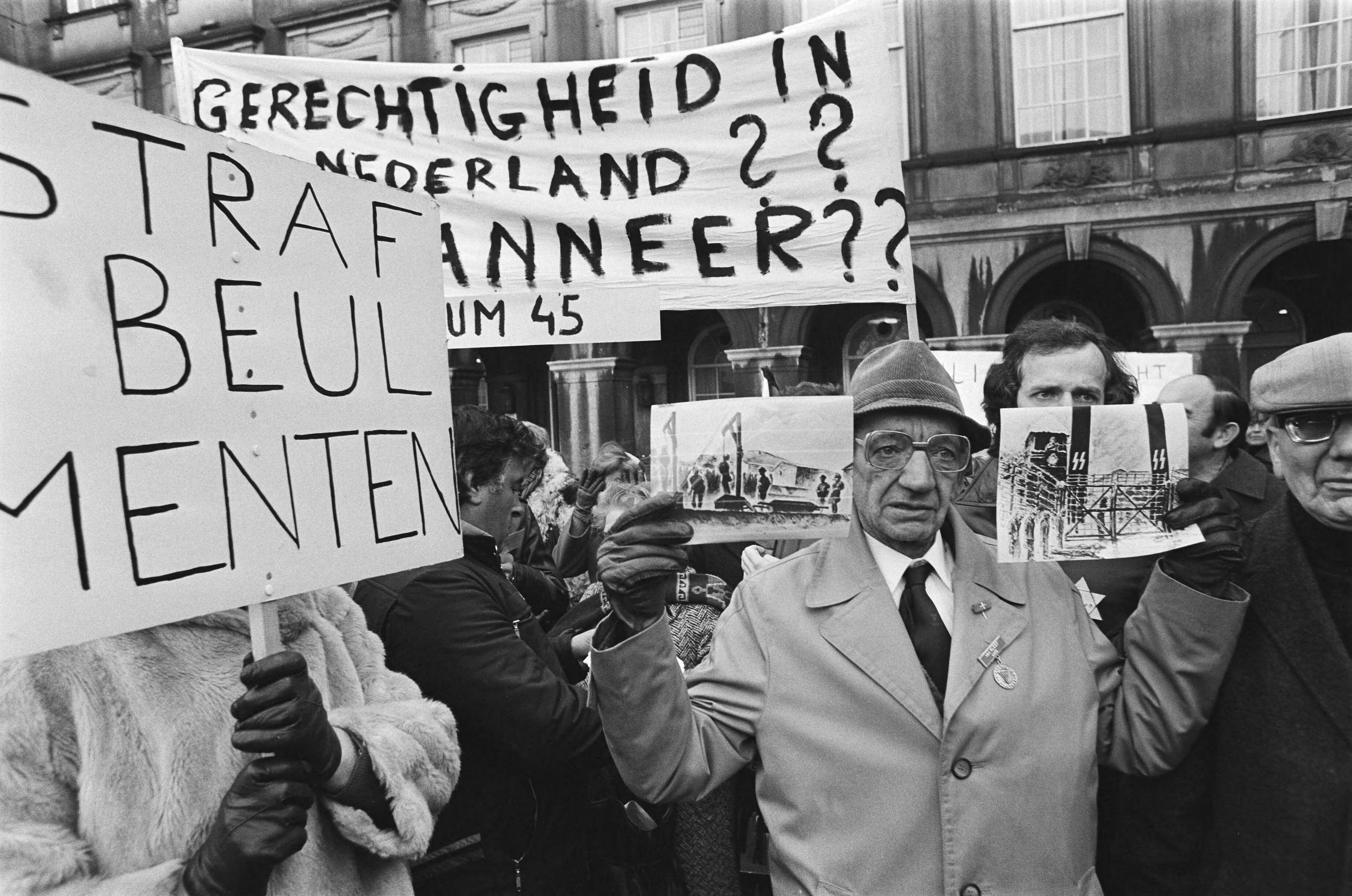 Fotocollectie Anefo — Demonstratie tegen vrijlating Menten op Binnenhof ( Den Haag ); demonstrant met fotos van kampen — Foto: Croes, Rob C. / Anefo. Licentie: Set B: Rechtenvrij / Publiek Domein. Bron: Nationaal Archief. http://hdl.handle.net/10648/acc0daa0-d0b4-102d-bcf8-003048976d84