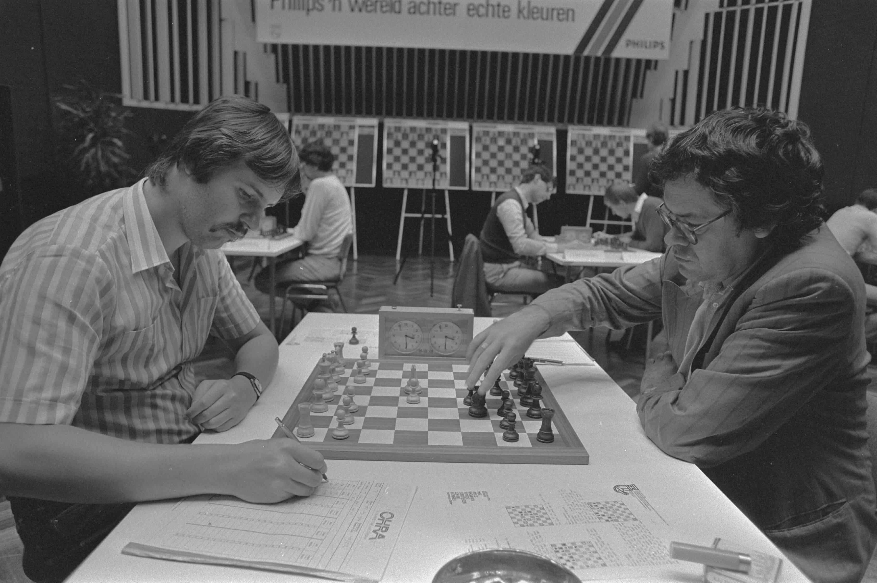 Fotocollectie Anefo — Nederlandse kampioenschappen schaken in Hilversum; Johan van de Wiel (l) tegen Hans Ree — Foto: Bogaerts, Rob / Anefo. Licentie: Set B: Rechtenvrij / Publiek Domein. Bron: Nationaal Archief. http://hdl.handle.net/10648/ad3ccd72-d0b4-102d-bcf8-003048976d84