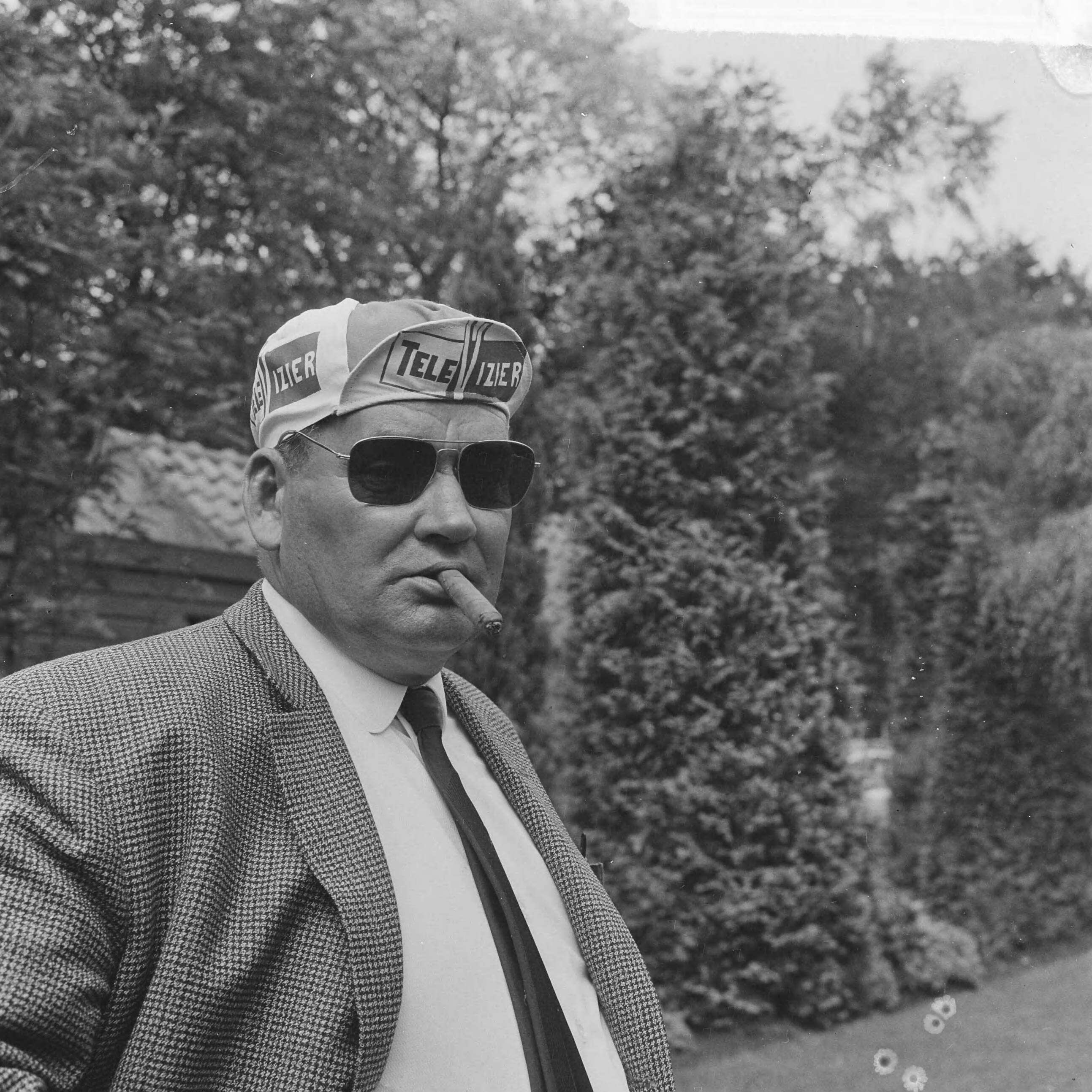 Fotocollectie Anefo — Televizierploeg voor de Tour de France in Hotel De Zwaan te Etten voorgesteld, ploegleider Kees Pellenaars (met zonnebril en sigaar) — Foto: Evers, Joost / Anefo. Licentie: Set B: Rechtenvrij / Publiek Domein. Bron: Nationaal Archief. http://hdl.handle.net/10648/aaadb530-d0b4-102d-bcf8-003048976d84