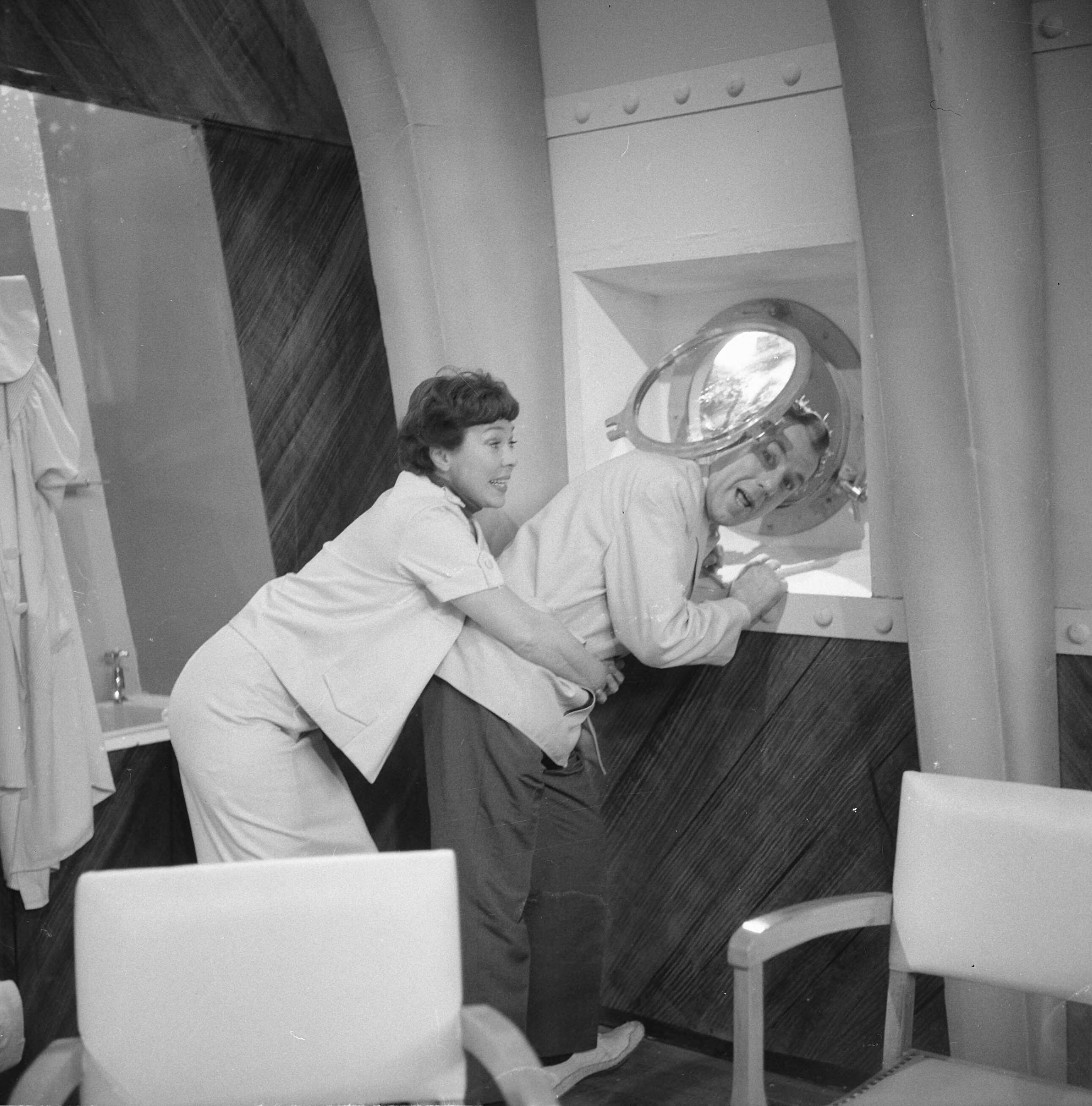 Fotocollectie Anefo — Opname televisiespel "Met 24 pk door Europa" (uitzending niet doorgegaan). Teddy Schaank en Ko van DijkNegatieven zijn een jaar later, op 31-3-1964, geregistreerd in fotoadministratie Anefo! Deze aflevering is wél uitgezonden, als eerste op 20-10-1963. Op 22-11-1963 schrijft Trouw: Er komen geen afleveringen meer van de televisiestrip "Met 24 P.K. door Europa" met Ko van Dijk, Teddy Schaank en Simone Rooskens. De AVRO heeft besloten de serie te staken. Reden: de strip kon ook na bewerking van het oorspronkelijke script niet aan de gestelde eisen voldoen. Karel Prior, hoofd amusementsprogramma's van de AVRO zei van deze door het echtpaar Mazure geschreven strip, dat ze „te filmisch" waren geschreven, waardoor men er in de televisiestudio's niet goed mee uit de voeten kon. Ellen en Georges Mazure, die zes afleveringen van hun strip aan de AVRO verkochten, liggen al een poosje overhoop met de AVRO in verband met de televisie-uitzendingen van hun script. Vooral de ver