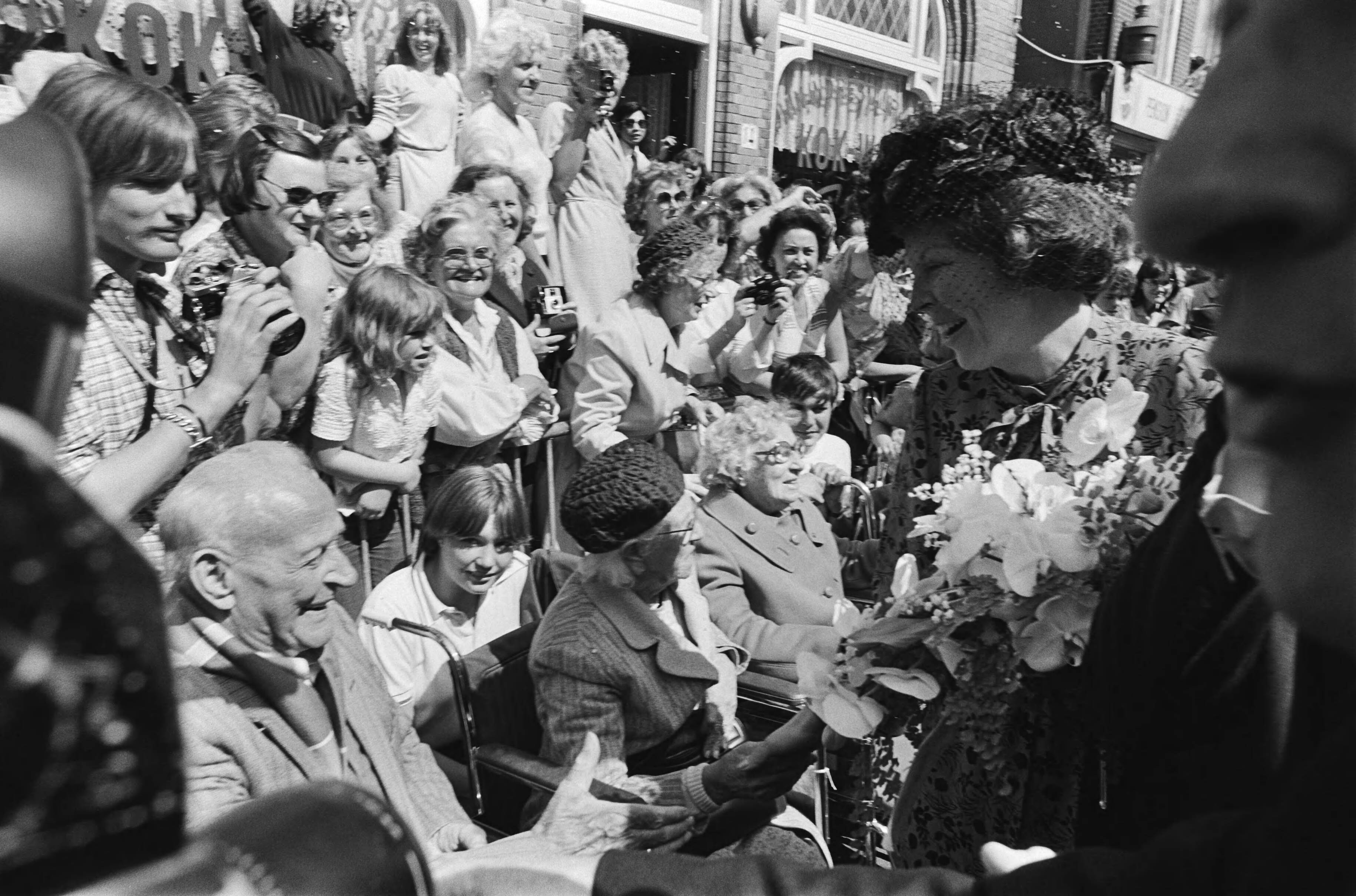 Fotocollectie Anefo — Intocht Koningin Beatrix in Den Haag overzicht drukte tijdens wandeling Koninklijke familie in Scheveningen, tijdens wandeling (HM begroet bejaarden) — Foto: Croes, Rob C. / Anefo. Licentie: Set B: Rechtenvrij / Publiek Domein. Bron: Nationaal Archief. http://hdl.handle.net/10648/ace0e174-d0b4-102d-bcf8-003048976d84