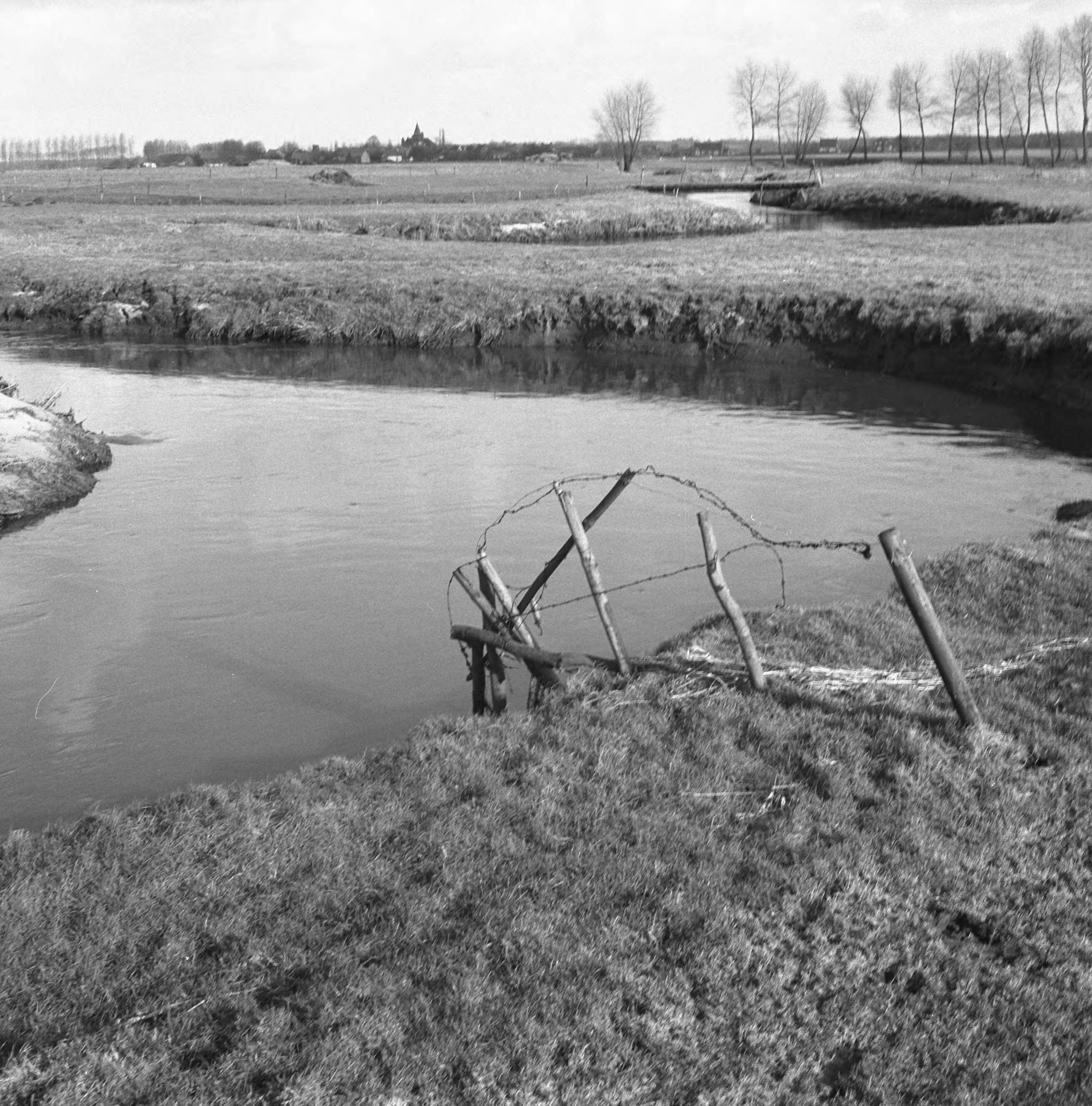 Fotocollectie Nederlandse Heidemaatschappij — Ruilverkaveling Essche Stroom vak III (bestaande toestand). Kronkelig deel van de Essche Stroom met brug van de landbouwer Van de Sande. Op de achtergrond de kerktoren van Esch — Foto: Wüllschleger, [...] / Heidemij. Licentie: Set B: Rechtenvrij / Publiek Domein. Bron: Nationaal Archief. http://hdl.handle.net/10648/ae74573c-d0b4-102d-bcf8-003048976d84