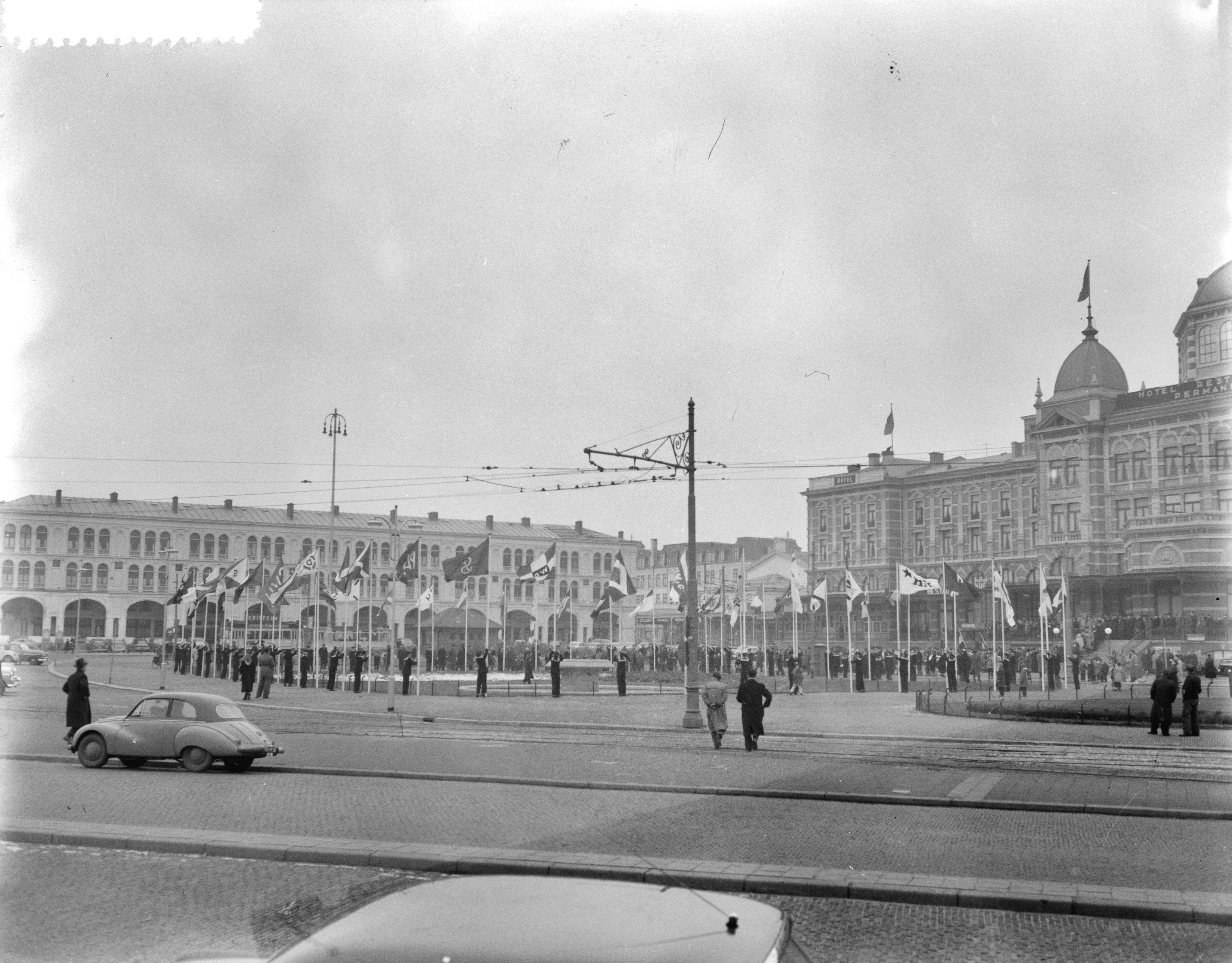 Fotocollectie Anefo — Viering gouden jubileum (50-jarig bestaan) van de Nederlandsche Reedersvereniging in het Kurhaus te Scheveningen. Op het Gevert Deynootplein worden vlaggen van rederijen gehesen door jongens van de "Pollux" uit Amsterdam — Foto: Pot, Harry / Anefo. Licentie: Set B: Rechtenvrij / Publiek Domein. Bron: Nationaal Archief. http://hdl.handle.net/10648/a93131a0-d0b4-102d-bcf8-003048976d84