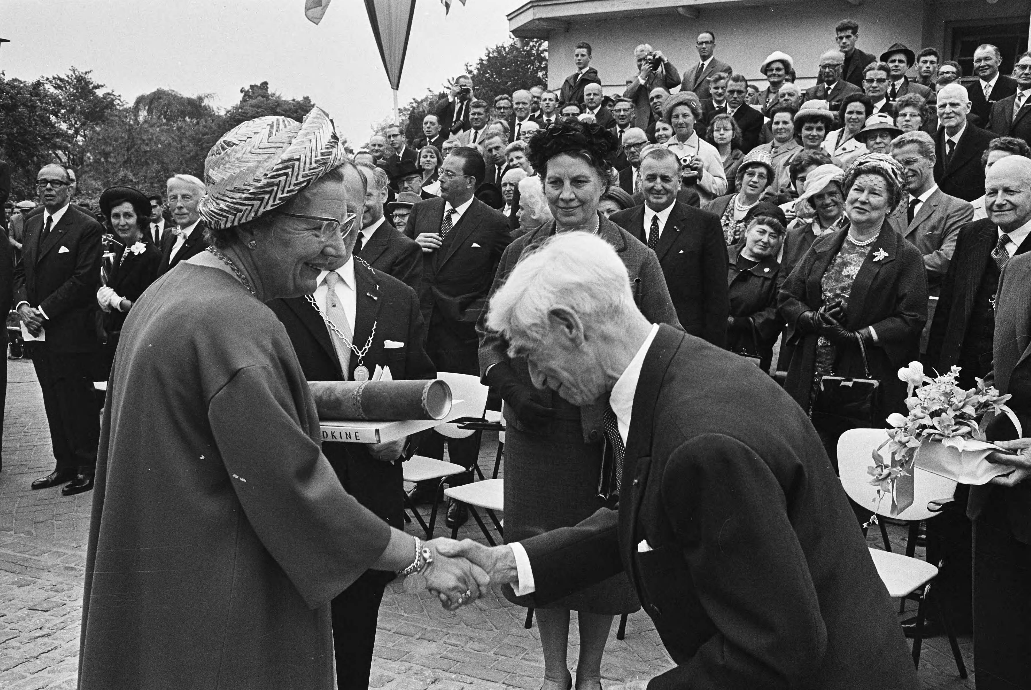 Koningin Juliana onthult het Van Gogh-monument in Zundert — Kunstenaar Ossip Zadkine overhandigt koningin Juliana een gravure en een boek waarvoor zij hem bedankt — Foto: Fotograaf Onbekend / Anefo. Licentie: Set B: Rechtenvrij / Publiek Domein. Bron: Nationaal Archief. http://hdl.handle.net/10648/aa6afb3c-d0b4-102d-bcf8-003048976d84