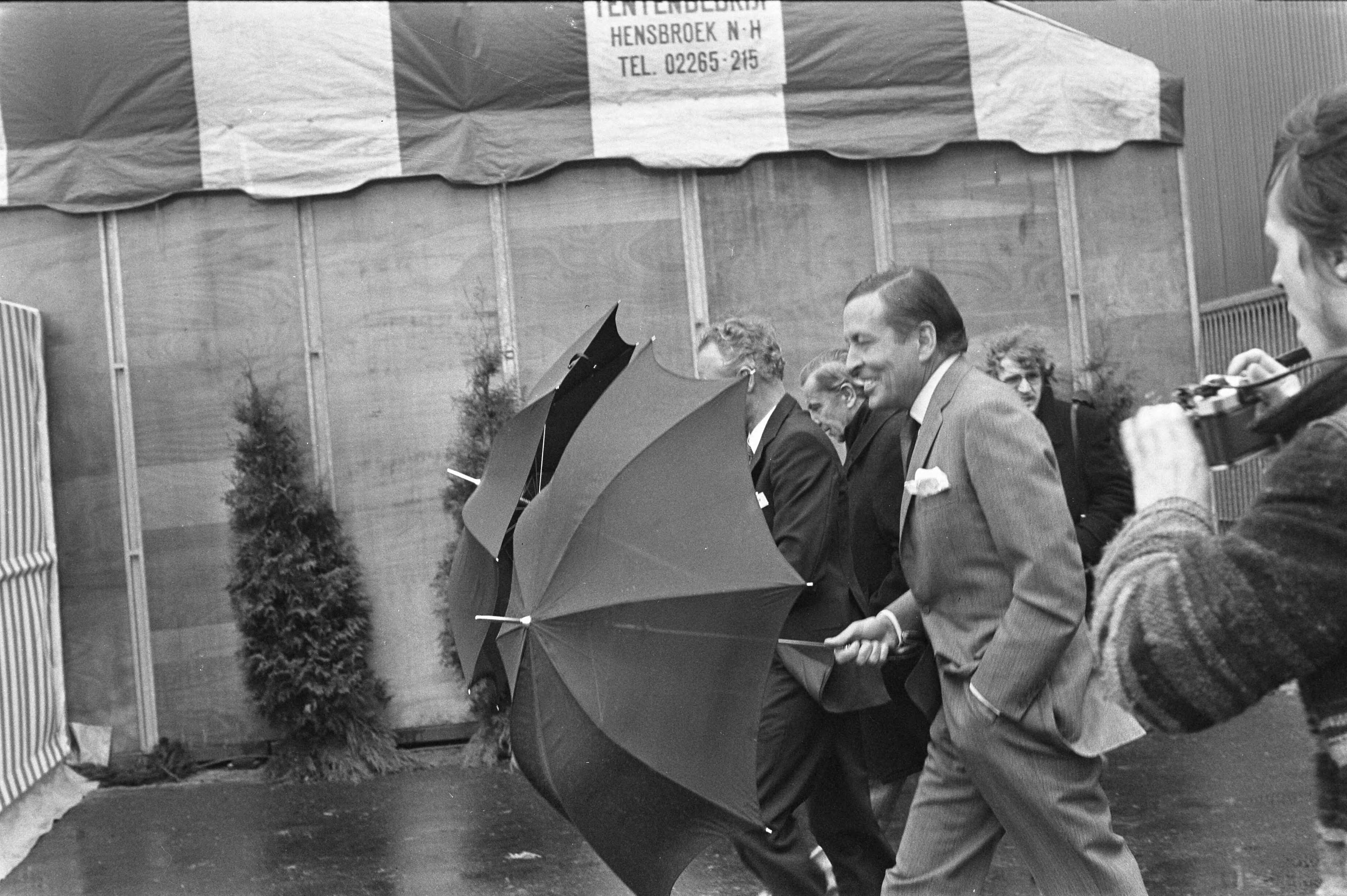 Fotocollectie Anefo — Prins Claus bij opening Trelleborg in Hoogezond (Groningen); Prins Claus met paraplu op fabrieksterrein — Foto: Mieremet, Rob / Anefo. Licentie: Set B: Rechtenvrij / Publiek Domein. Bron: Nationaal Archief. http://hdl.handle.net/10648/ac5b770a-d0b4-102d-bcf8-003048976d84