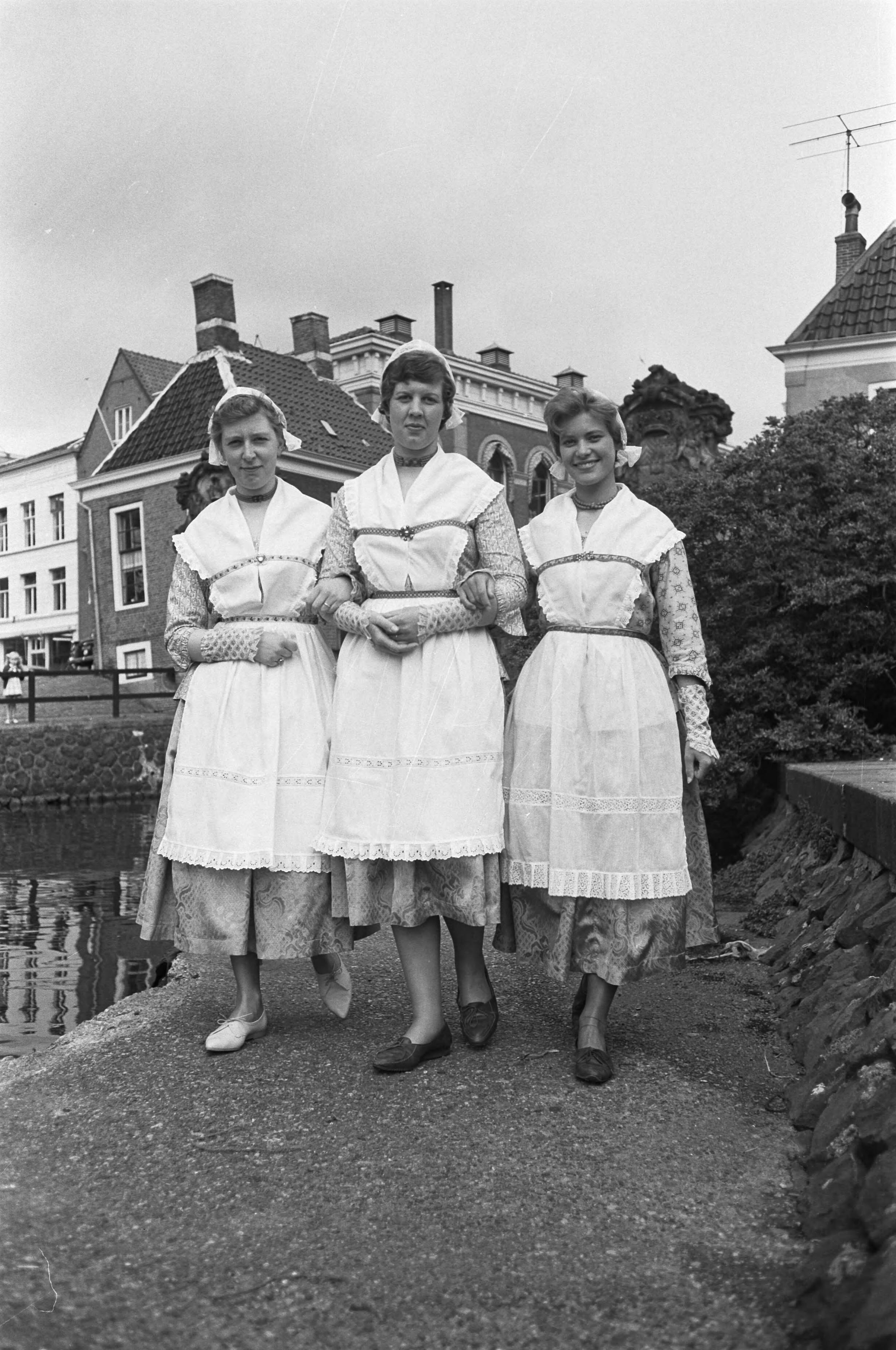 Fotocollectie Anefo — Voorbereidingen voor de feestelijkheden ter gelegenheid van viering 150 jaar stadsrechten van Zaandam. Drie jonge vrouwen in Noord-Hollandse klederdracht — Foto: Pot, Harry / Anefo. Licentie: Set B: Rechtenvrij / Publiek Domein. Bron: Nationaal Archief. http://hdl.handle.net/10648/a9d6a2f2-d0b4-102d-bcf8-003048976d84