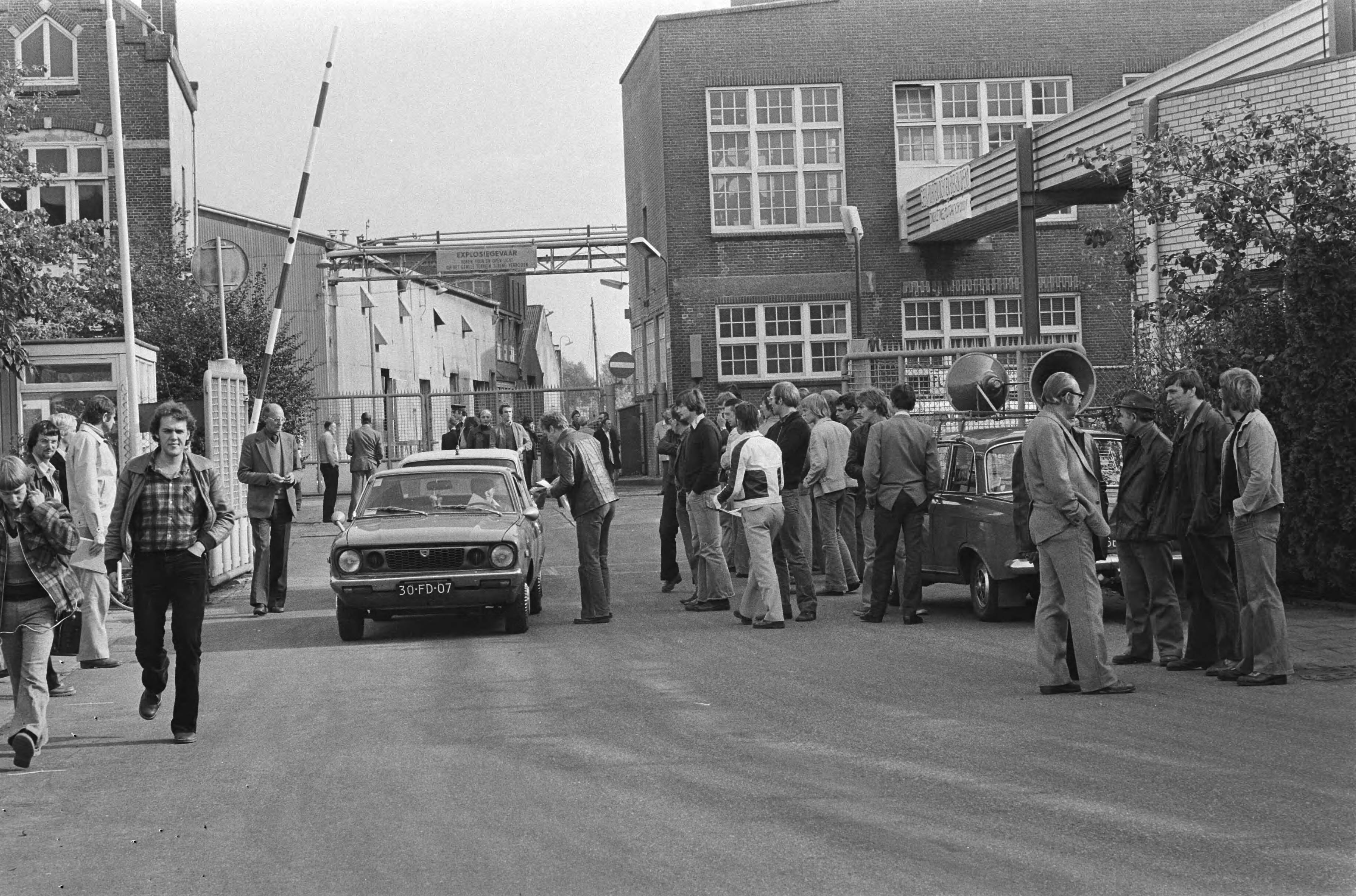 Fotocollectie Anefo — Staking van enkele uren personeel Scholten Honig ; staken bij de poort in Koog aan de Zaan — Foto: Suyk, Koen / Anefo. Licentie: Set B: Rechtenvrij / Publiek Domein. Bron: Nationaal Archief. http://hdl.handle.net/10648/aca44318-d0b4-102d-bcf8-003048976d84