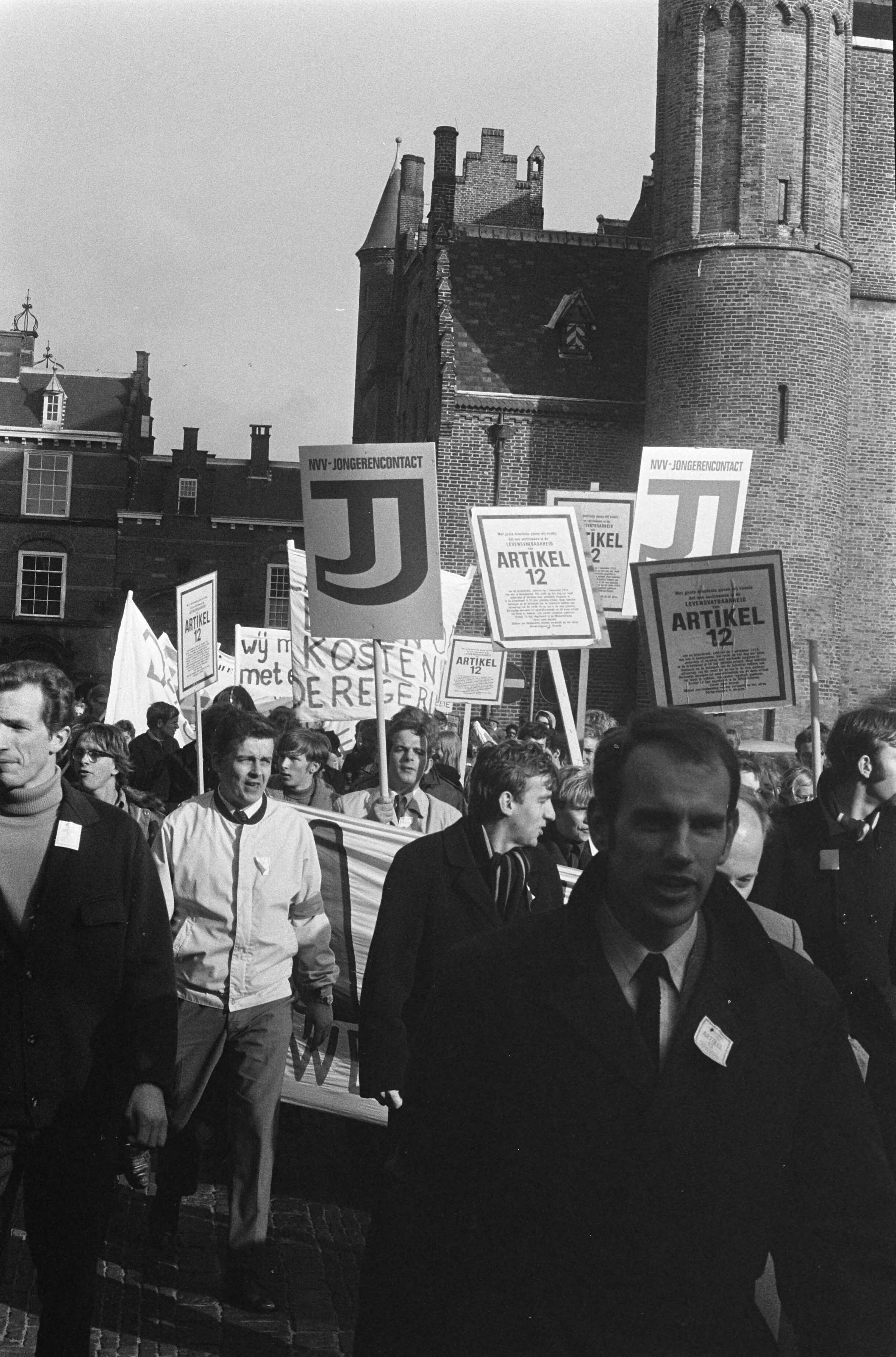 Fotocollectie Anefo — Demonstratie van Werkende Jongeren in Den Haag . Demonstranten op Binnenhof met borden — Foto: Verhoeff, Bert / Anefo. Licentie: Set B: Rechtenvrij / Publiek Domein. Bron: Nationaal Archief. http://hdl.handle.net/10648/ab7fb904-d0b4-102d-bcf8-003048976d84