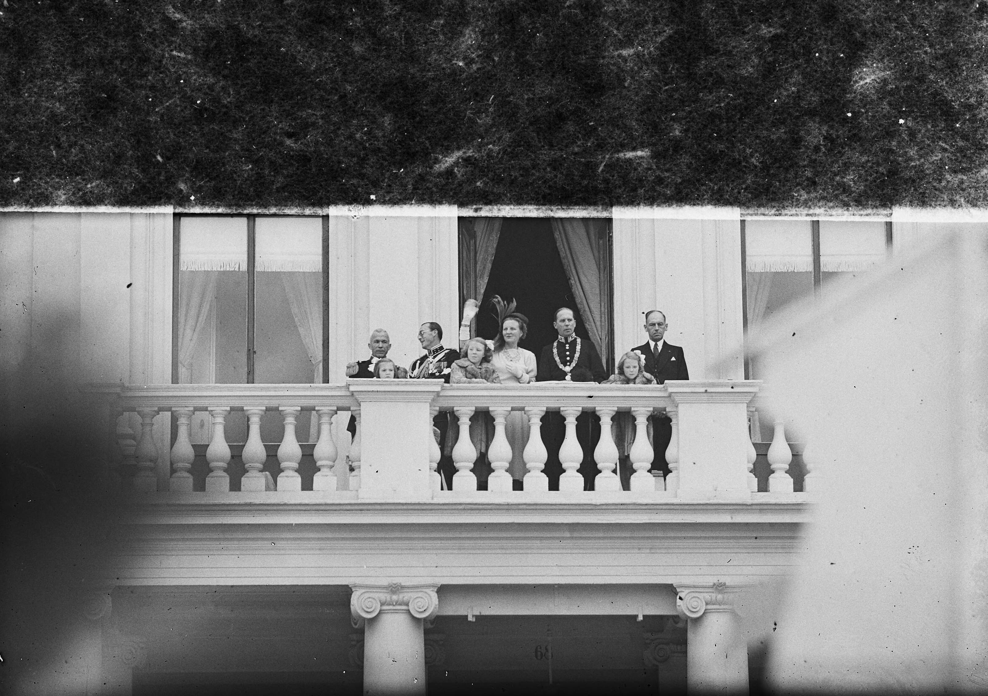Intocht van koningin Juliana in Den Haag (1948) — Intocht Koningin Juliana in Den Haag. Koninklijke familie op het balkon. Koningin wuift — Foto: Bilsen, Joop van / Anefo. Licentie: Set B: Rechtenvrij / Publiek Domein. Bron: Nationaal Archief. http://hdl.handle.net/10648/a8bd2efe-d0b4-102d-bcf8-003048976d84