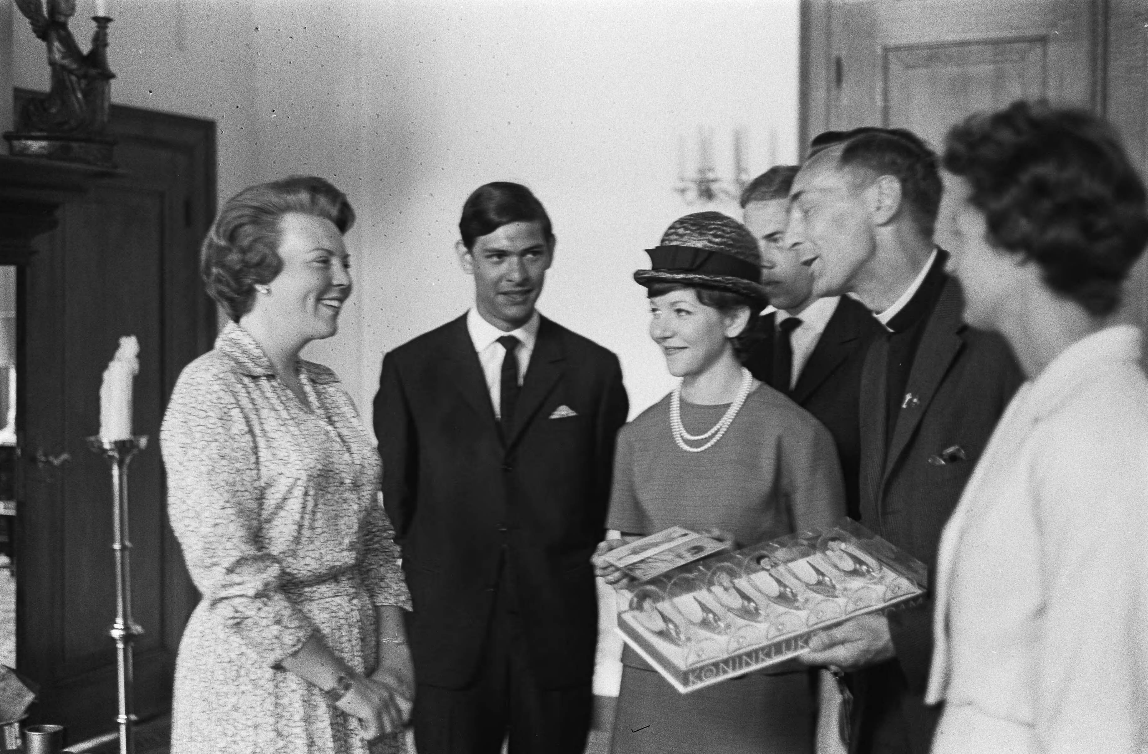 Fotocollectie Anefo — Prinses Beatrix heeft op Kasteel Drakensteyn het actie-comité "Dousadsj" ontvangen, v.l.n.r. Prinses Beatrix , dhr. Rompius, Miss Dousadsj [Adele Rompius-Sadrille], P. van Bueren, pater Werenfreid Stokman en mevrouw J. Rigby (penningmeester Europese werkgroep). Pater Stokman biedt de prinses een set glazen aan met de gegraveerde portretten en handtekeningen van Nederlandse artiesten, vervaardigd door Koninklijke Leerdam — Foto: Pot, Harry / Anefo. Licentie: Set B: Rechtenvrij / Publiek Domein. Bron: Nationaal Archief. http://hdl.handle.net/10648/aa393674-d0b4-102d-bcf8-003048976d84