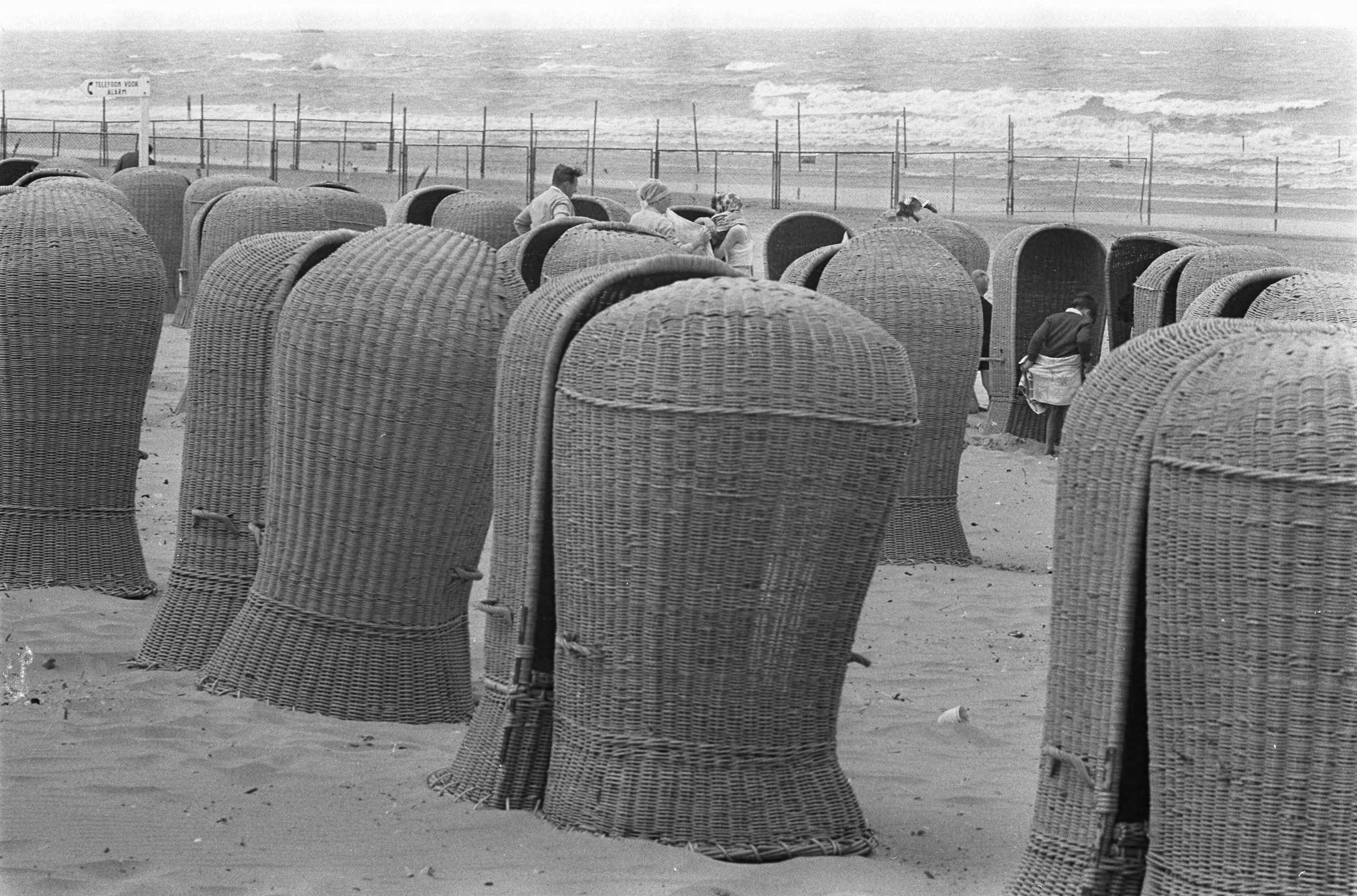 Zomer 1967 — Enthousiaste buitenlanders zoeken een plaatsje uit de wind — Foto: Fotograaf Onbekend / Anefo. Licentie: Set B: Rechtenvrij / Publiek Domein. Bron: Nationaal Archief. http://hdl.handle.net/10648/ab1da098-d0b4-102d-bcf8-003048976d84