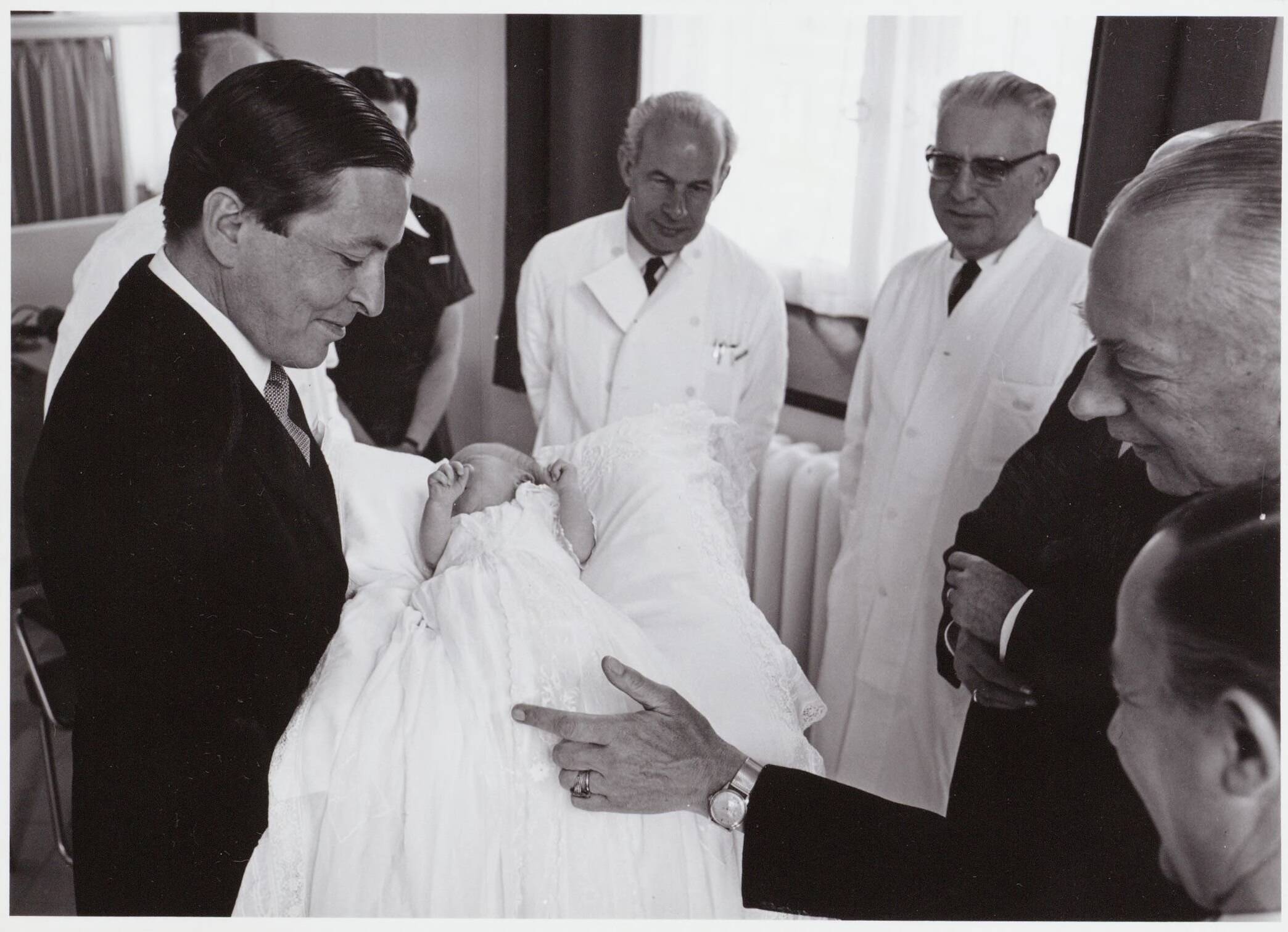 Fotocollectie RVD / Koninklijk Huis — Prins Claus toont de baby prins Willem-Alexander aan de doktoren in het Academisch Ziekenhuis Utrecht op 2 mei 1967 — Foto: Nationaal Foto Persbureau / RVD. Licentie: Set B: Rechtenvrij / Publiek Domein. Bron: Nationaal Archief. http://hdl.handle.net/10648/afaf327a-d0b4-102d-bcf8-003048976d84