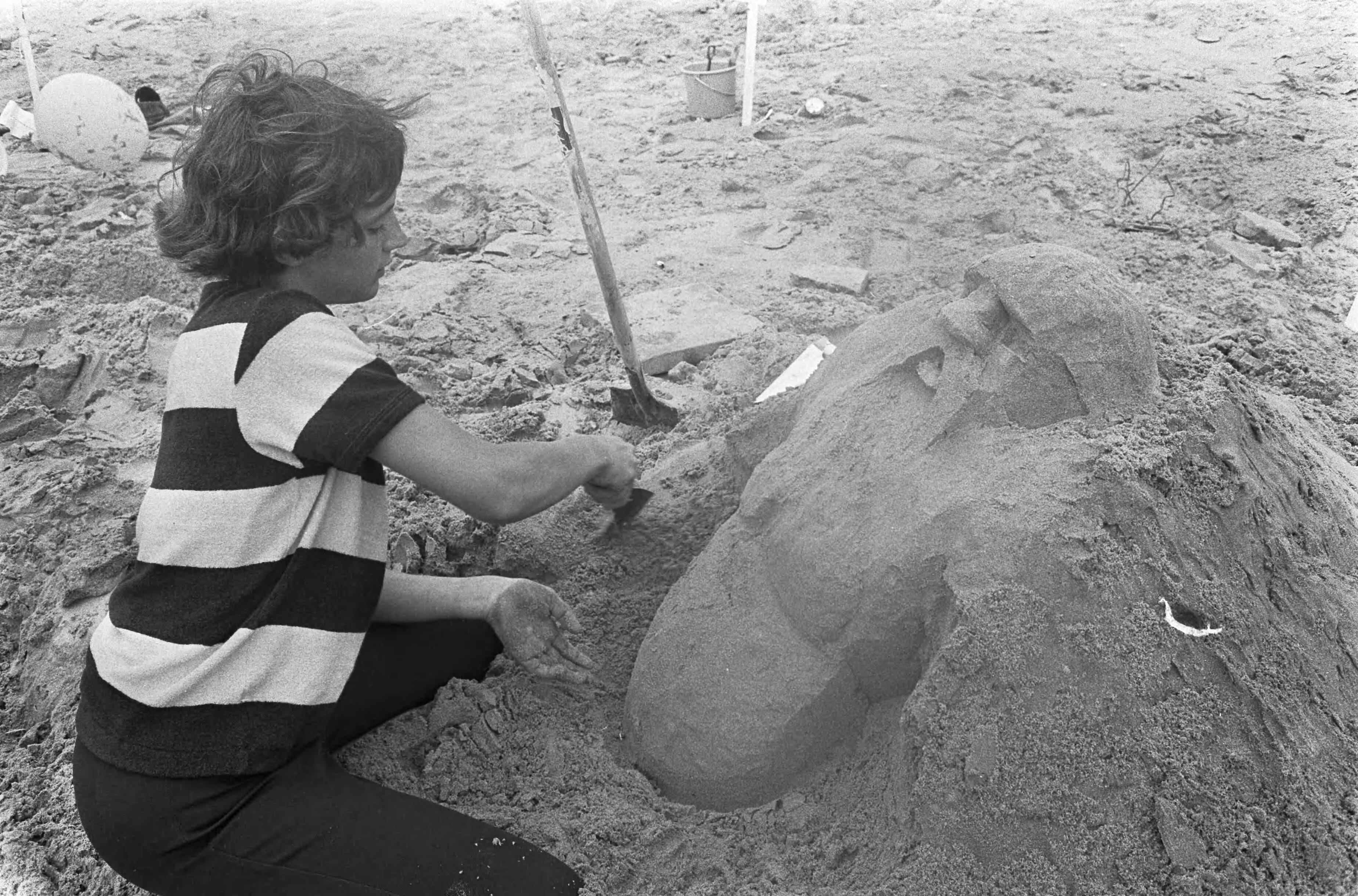 Finale Zandbouwwedstrijd op strand Scheveningen — Deelnemer aan het werk — Foto: Fotograaf Onbekend / Anefo. Licentie: Set B: Rechtenvrij / Publiek Domein. Bron: Nationaal Archief. http://hdl.handle.net/10648/ab1f1c70-d0b4-102d-bcf8-003048976d84