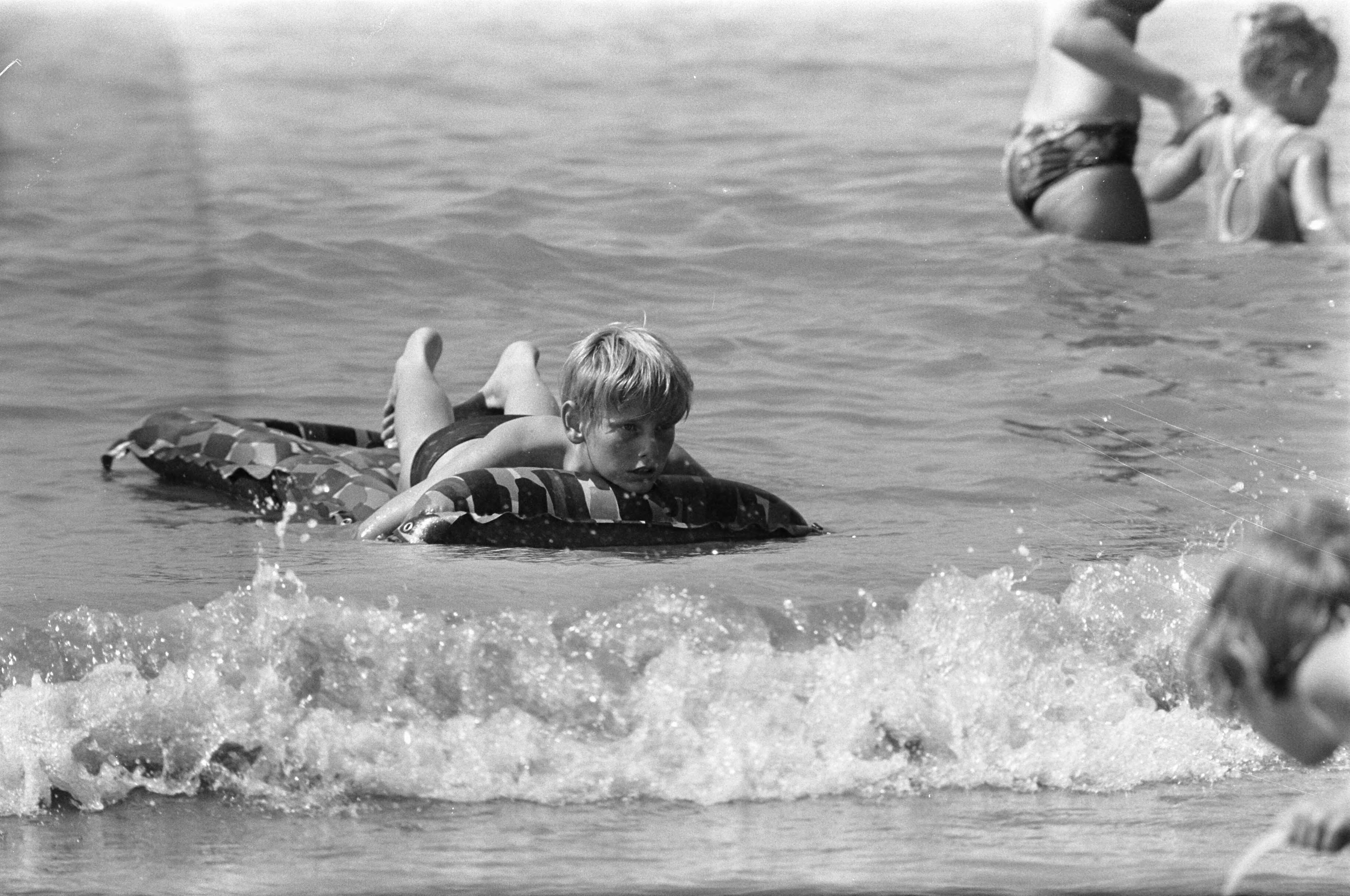 Strandleven in Zandvoort — Kind op luchtbed in zee — Foto: Fotograaf Onbekend / Anefo. Licentie: Set B: Rechtenvrij / Publiek Domein. Bron: Nationaal Archief. http://hdl.handle.net/10648/ab732dd8-d0b4-102d-bcf8-003048976d84