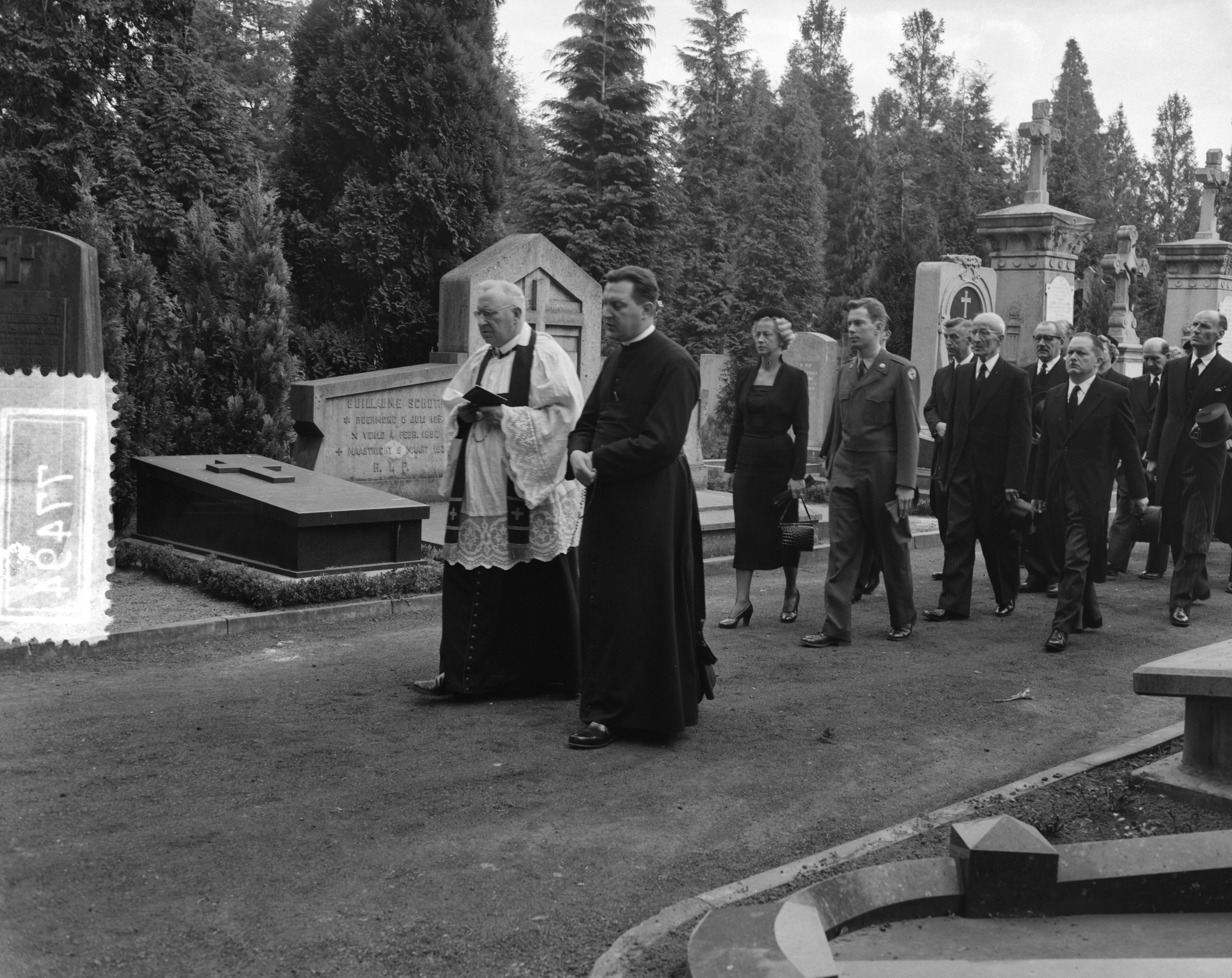 Fotocollectie Anefo — Begrafenis van Leon Jungschläger te Maastricht. Pastoor-deken van Maastricht P.J.M. Jennekens leidt de uitvaart. Achter hem de echtgenote en zoon van Leon Jungschläger — Foto: Rossem, Wim van / Anefo. Licentie: Set B: Rechtenvrij / Publiek Domein. Bron: Nationaal Archief. http://hdl.handle.net/10648/a947a4bc-d0b4-102d-bcf8-003048976d84
