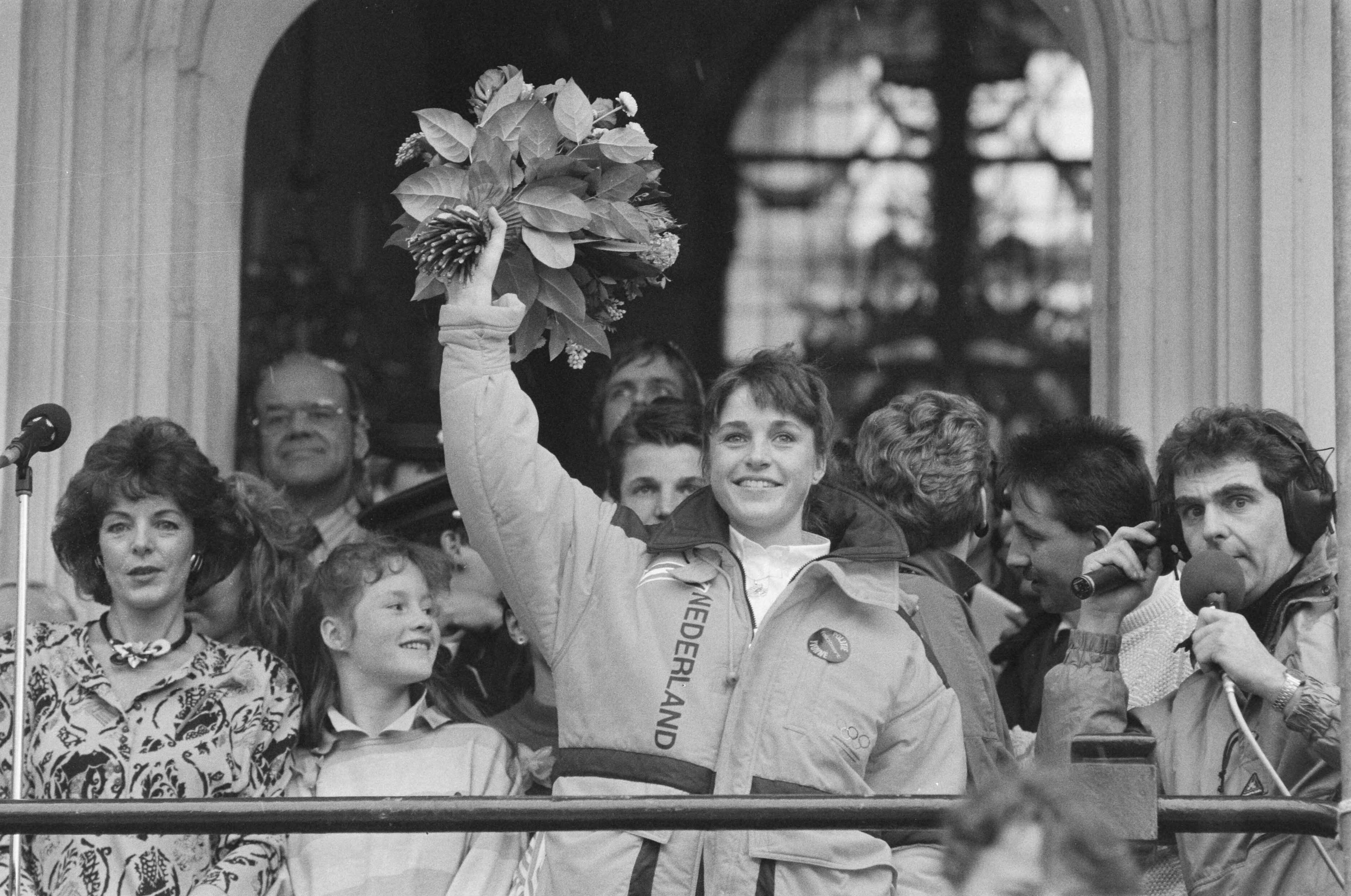 Fotocollectie Anefo — Yvonne van Gennip gehuldigd in Haarlem na behalen drie gouden medailles op de Olympische Spelen ; Yvonne zwaait met bloemen — Foto: Croes, Rob C. / Anefo. Licentie: Set B: Rechtenvrij / Publiek Domein. Bron: Nationaal Archief. http://hdl.handle.net/10648/ad68f014-d0b4-102d-bcf8-003048976d84