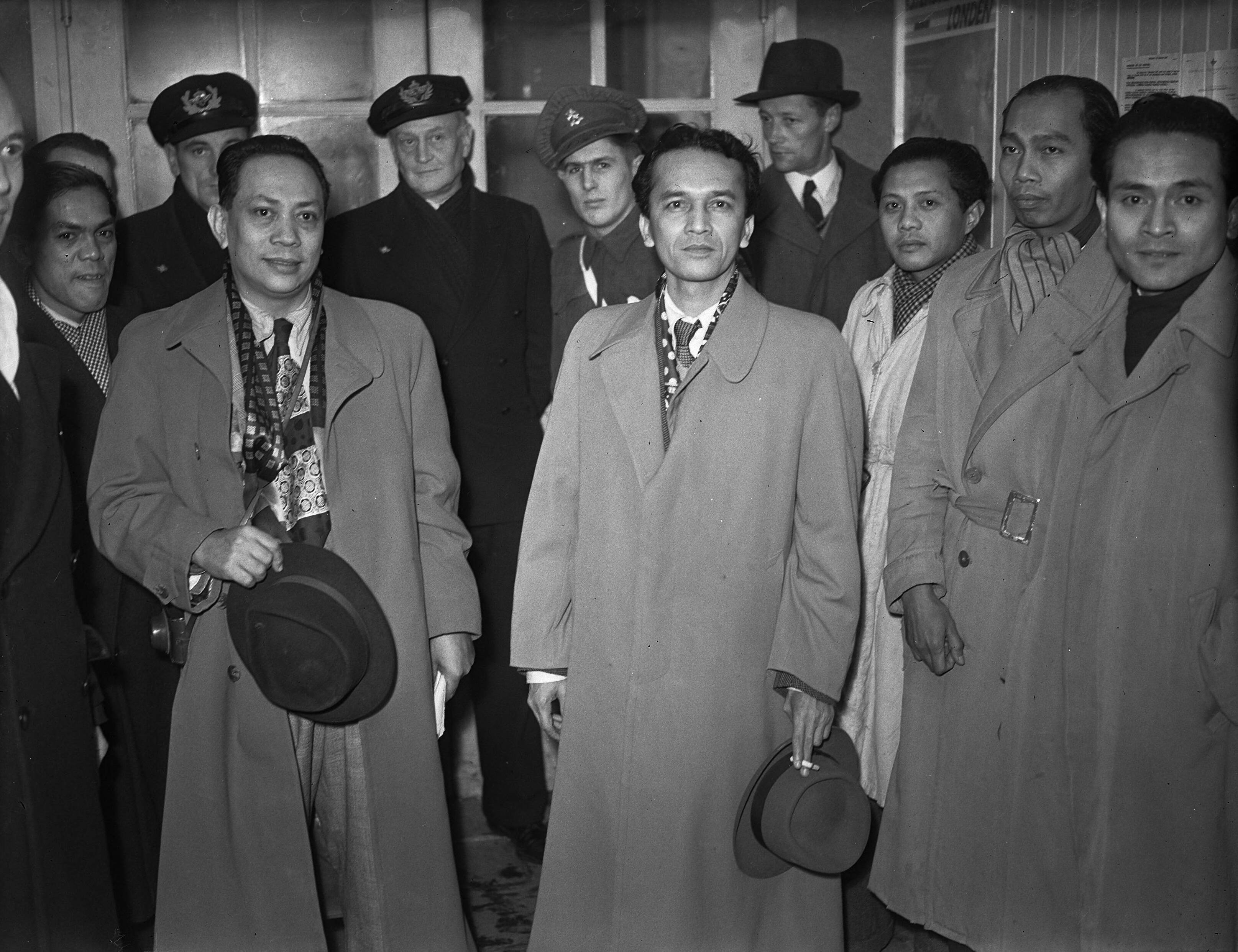 Fotocollectie Anefo — Dr. A.K. Gani, vice-premier van de Indonesische Republiek, tijdens een tussenlanding op Schiphol, poserend met mede-delegatieleden — Foto: Noske, J.D. / Anefo. Licentie: Set B: Rechtenvrij / Publiek Domein. Bron: Nationaal Archief. http://hdl.handle.net/10648/a8af79a8-d0b4-102d-bcf8-003048976d84