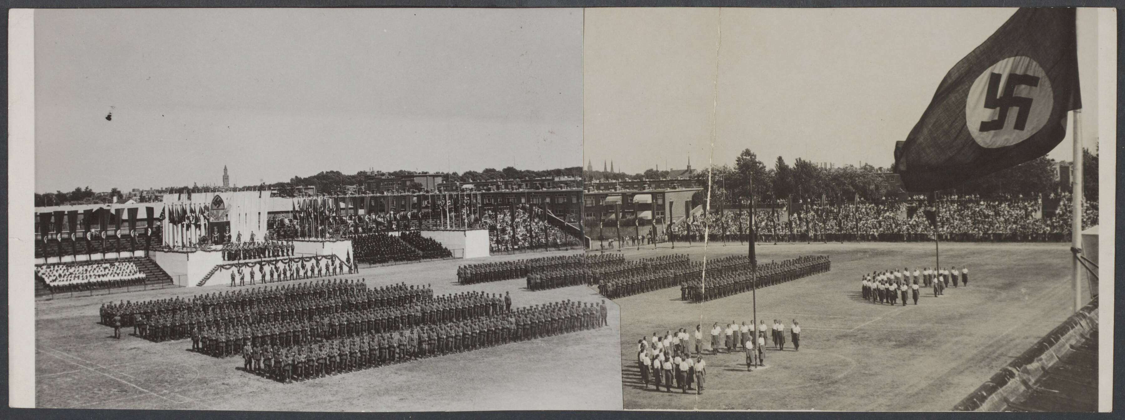 Arbeidsdienst. Waaronder "Nederlandse Arbeidsdienst" en "Vreugde en Arbeid" ("Fut door lol" 81). Ook opbouwdienst 1940/41. — Feestelijke bijeenkomst van de Reichsarbeitsdienst op Houtrust Den Haag — Foto: N.V. Polygoon. Licentie: Set B: Rechtenvrij / Publiek Domein. Bron: Nationaal Archief. http://hdl.handle.net/10648/3774bcd3-2b62-14c4-14db-7837e5a14c10