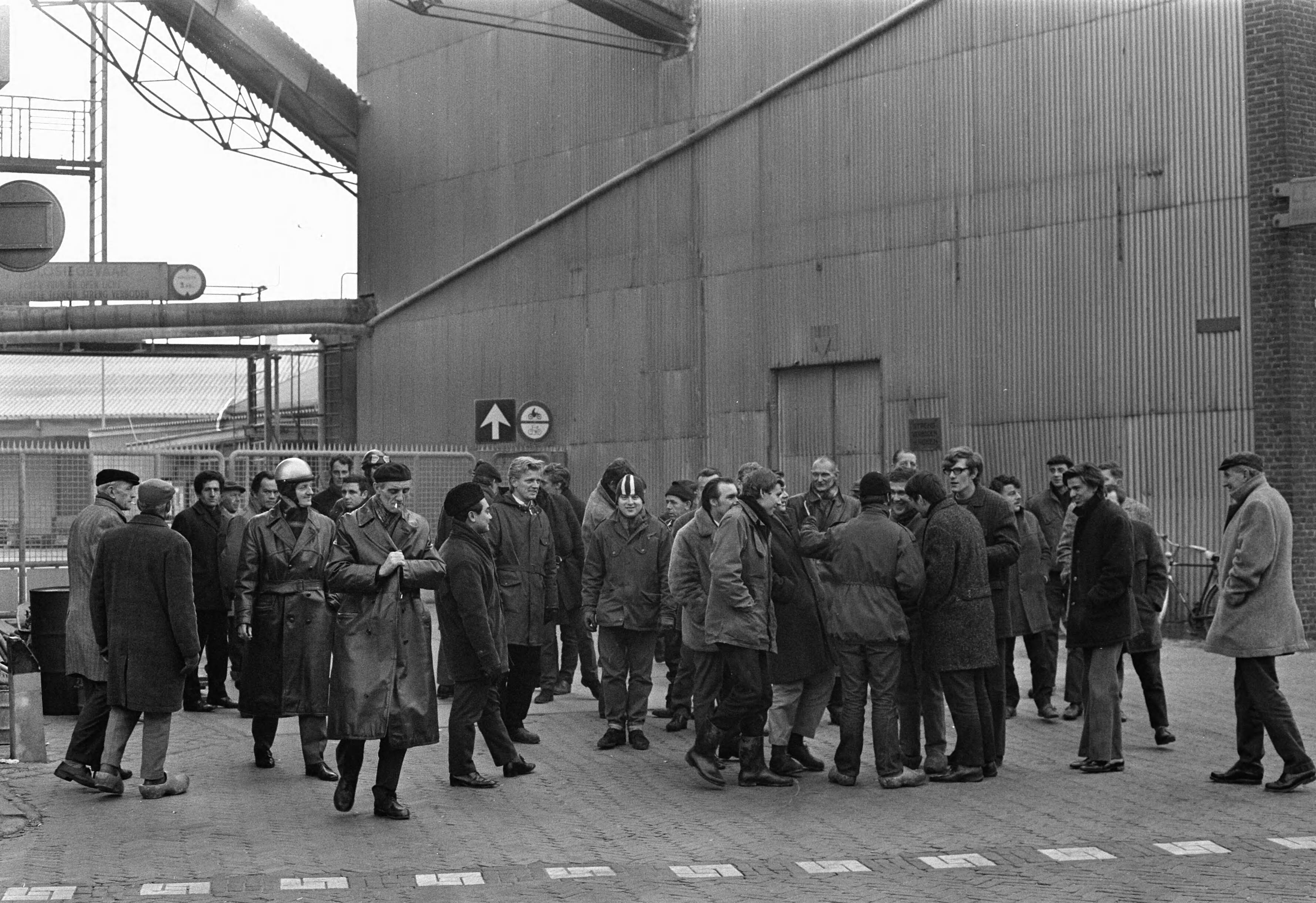 Fotocollectie Anefo — Werknemers van Honig in Koog aan de Zaan staken voor 1% duurtetoeslag en werktijdverkorting aan eind van de dag. Stakers bij ingang van "De Bijenkorf" — Foto: Evers, Joost / Anefo. Licentie: Set B: Rechtenvrij / Publiek Domein. Bron: Nationaal Archief. http://hdl.handle.net/10648/ab8638e2-d0b4-102d-bcf8-003048976d84