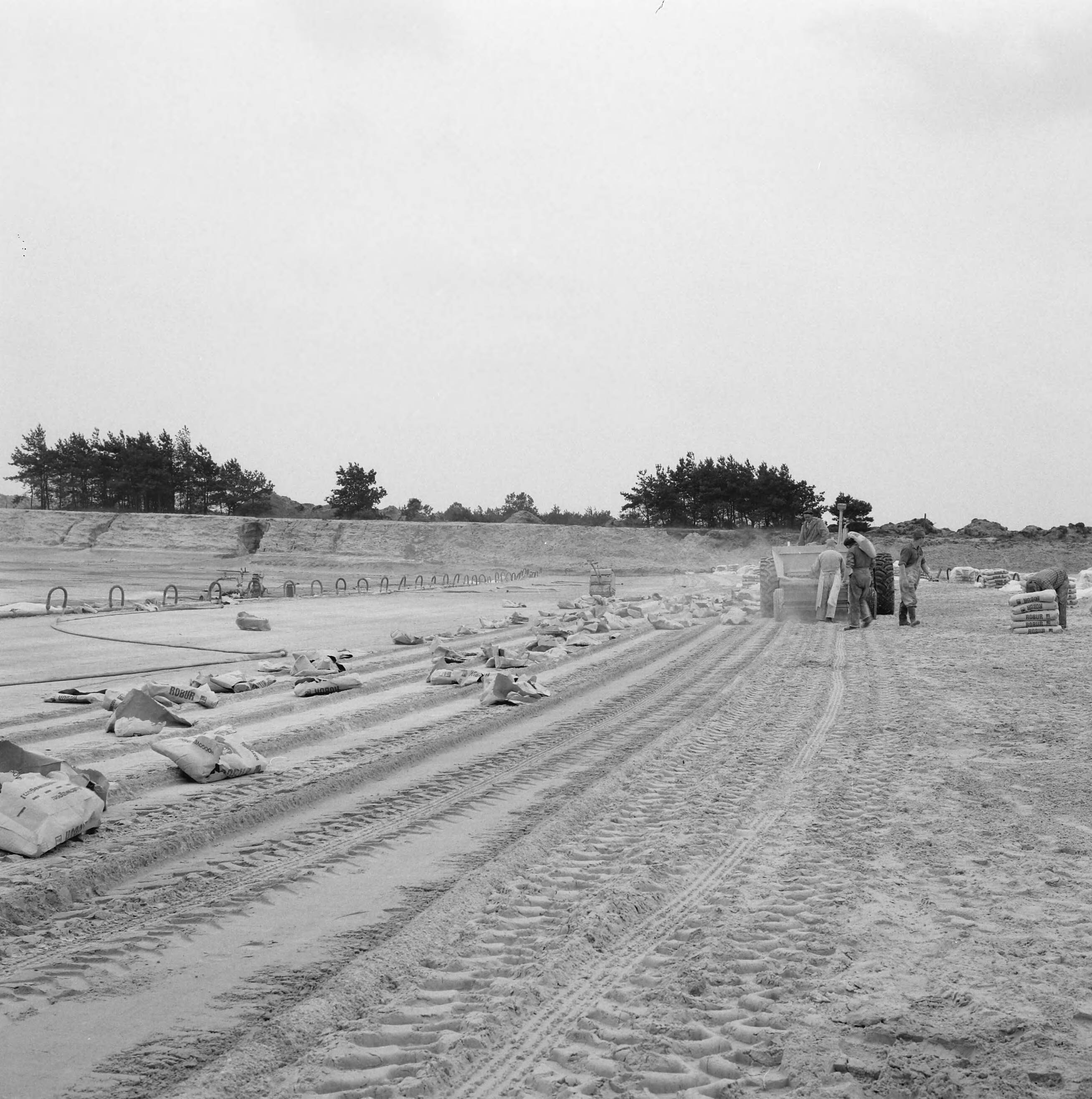 Fotocollectie Nederlandse Heidemaatschappij — Strandbad "Beekse Bergen". Het vullen in handkracht van de cementspreider — Foto: Wüllschleger, [...] / Heidemij. Licentie: Set B: Rechtenvrij / Publiek Domein. Bron: Nationaal Archief. http://hdl.handle.net/10648/ae851ce8-d0b4-102d-bcf8-003048976d84