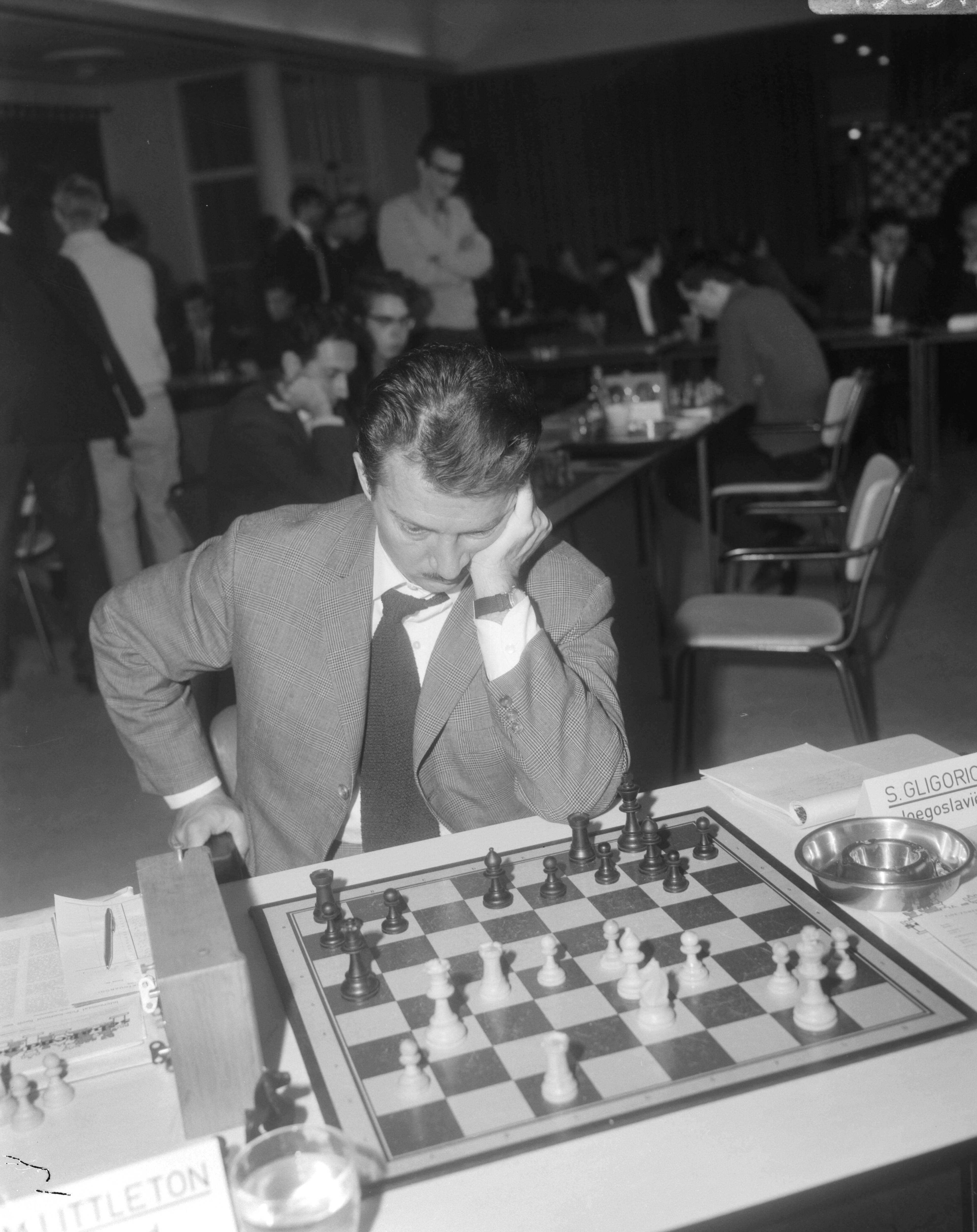 Fédération Internationale des Échecs (FIDE) -Zone schaaktoernooi 1966 in de kantine van 'De Nederlanden van 1845' te Den Haag — De Servische grootmeester Svetozar Gligoriæ aan het schaakbord — Foto: Bilsen, Joop van / Anefo. Licentie: Set B: Rechtenvrij / Publiek Domein. Bron: Nationaal Archief. http://hdl.handle.net/10648/ab000e3e-d0b4-102d-bcf8-003048976d84