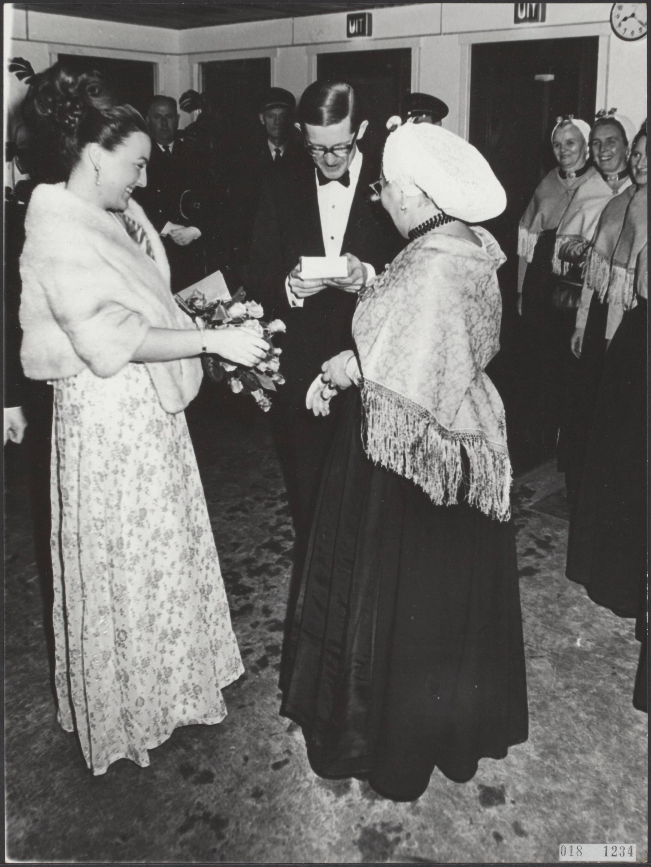 Fotocollectie Elsevier Binnenland — Feestelijke voorstelling in het Circusgebouw te Scheveningen voor de koninklijke gasten t.g.v. het huwelijk van prinses Margriet en mr. Pieter van Vollenhoven. Bij aankomst van het bruidspaar ontvingen zij van enige Scheveningse vissersvrouwen een geschenk — Foto: Kroon, Ron / Anefo. Licentie: Set B: Rechtenvrij / Publiek Domein. Bron: Nationaal Archief. http://hdl.handle.net/10648/adc4b0fc-d0b4-102d-bcf8-003048976d84