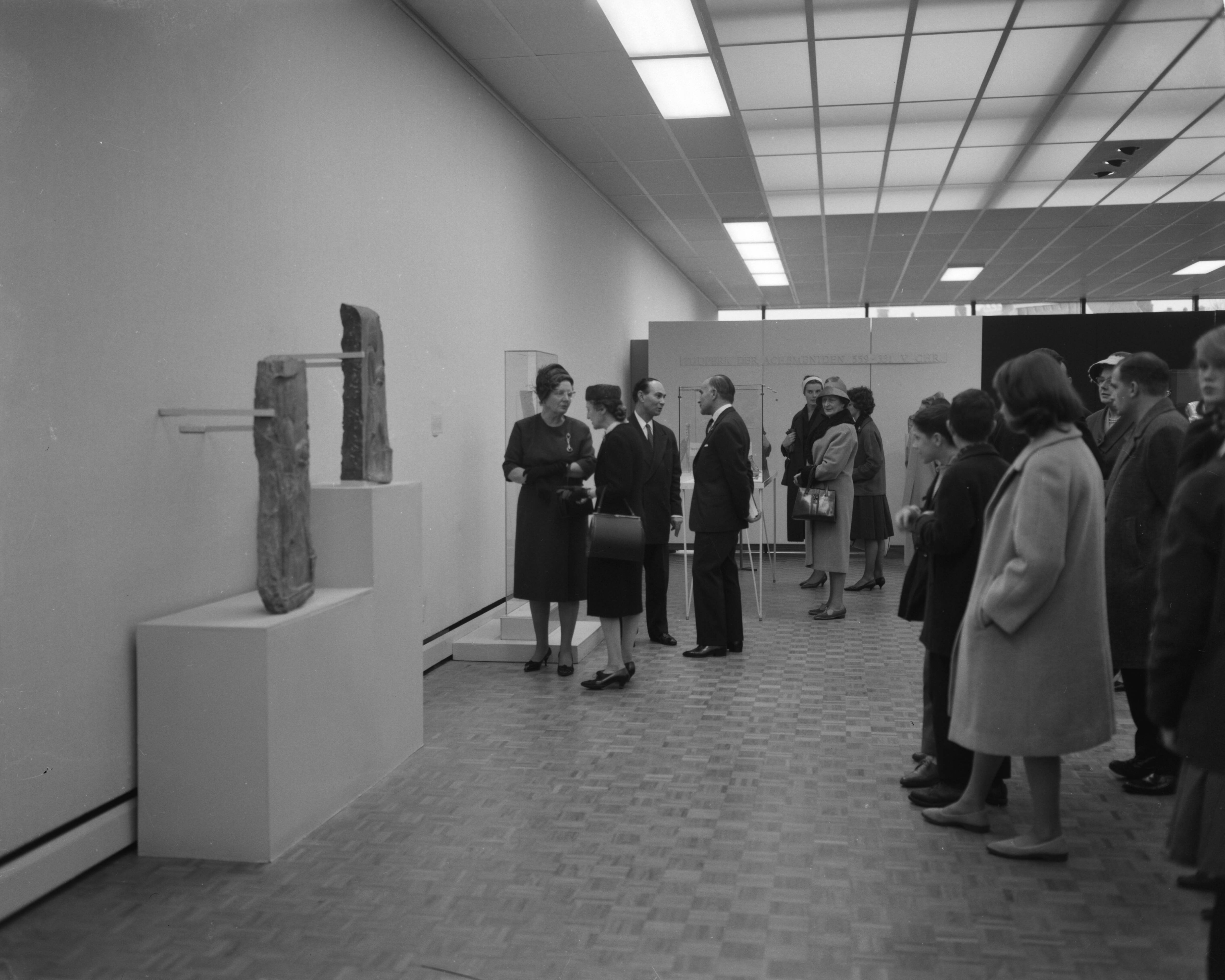 Fotocollectie Anefo — Koningin Juliana brengt een bezoek aan de tentoonstelling 7000 jaar Perzische Kunst te Den Haag. Tijdens de rondgang. De koningin in gesprek met mevr. Moghun en Louis Wijsenbeek (directeur) met dr. Ferydoun — Foto: Bilsen, Joop van / Anefo. Licentie: Set B: Rechtenvrij / Publiek Domein. Bron: Nationaal Archief. http://hdl.handle.net/10648/aa1dbdd6-d0b4-102d-bcf8-003048976d84