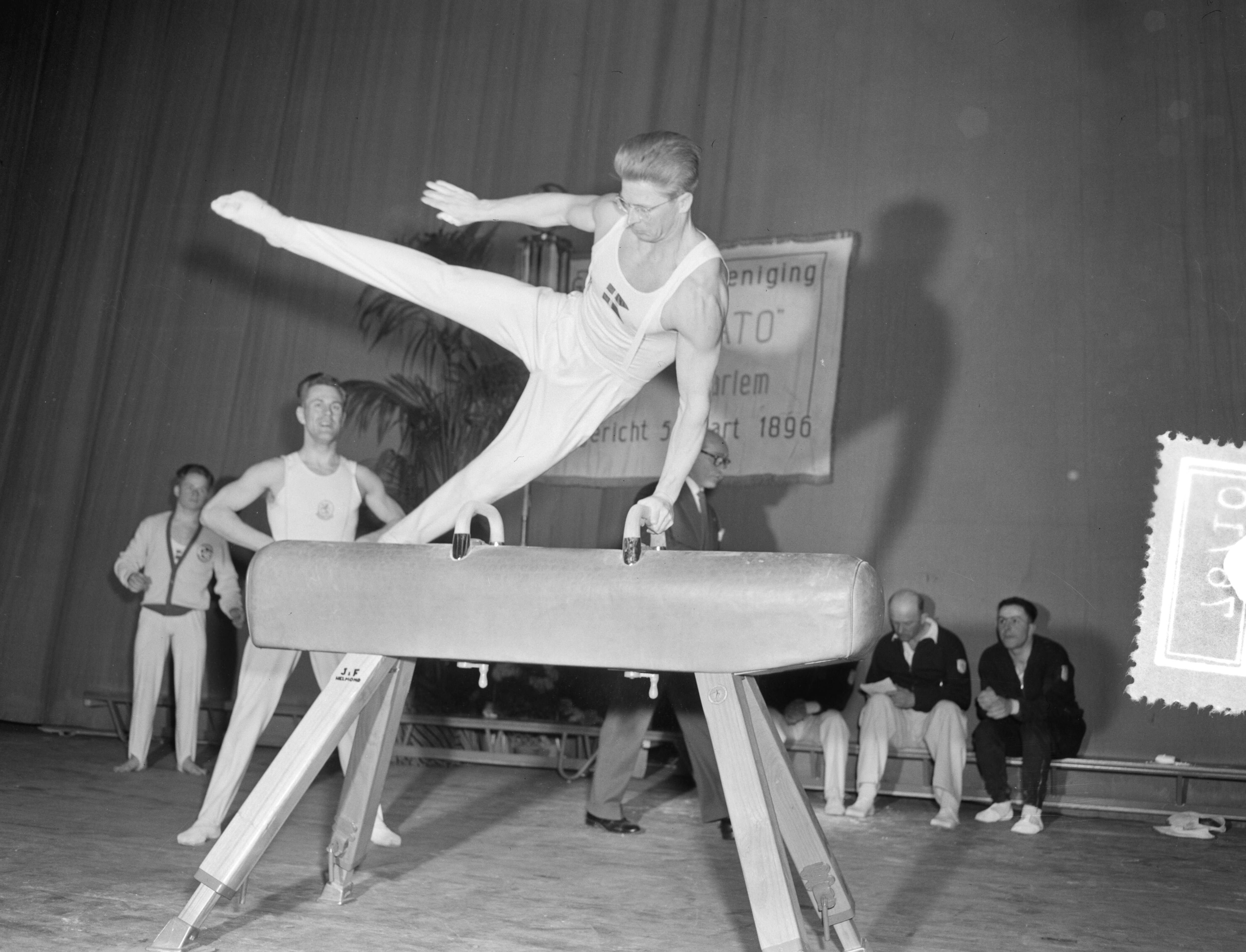 Fotocollectie Anefo — Turnen. Landenwedstrijd Nederland tegen Denemarken te Haarlem. Elkana Grønne (Denemarken) in actie bij paardvoltige. Klaas Boot kijkt toe — Foto: Pot, Harry / Anefo. Licentie: Set B: Rechtenvrij / Publiek Domein. Bron: Nationaal Archief. http://hdl.handle.net/10648/afd136ea-d0b4-102d-bcf8-003048976d84