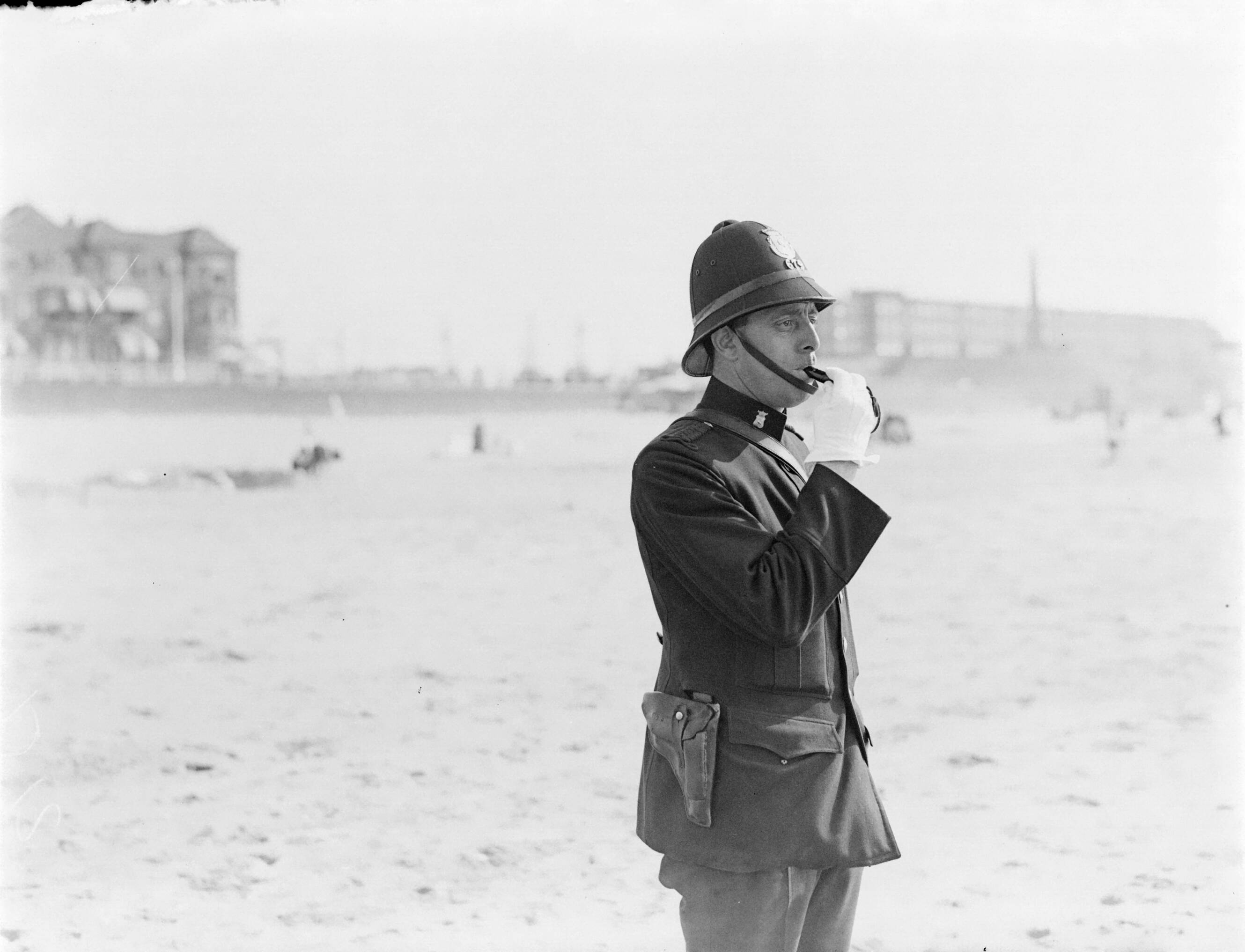 Strandtaferelen Scheveningen — Agent Jaspers blaast op zijn fluit — Foto: Poll, Willem van de. Licentie: Set B: Rechtenvrij / Publiek Domein. Bron: Nationaal Archief. http://hdl.handle.net/10648/aea860b8-d0b4-102d-bcf8-003048976d84