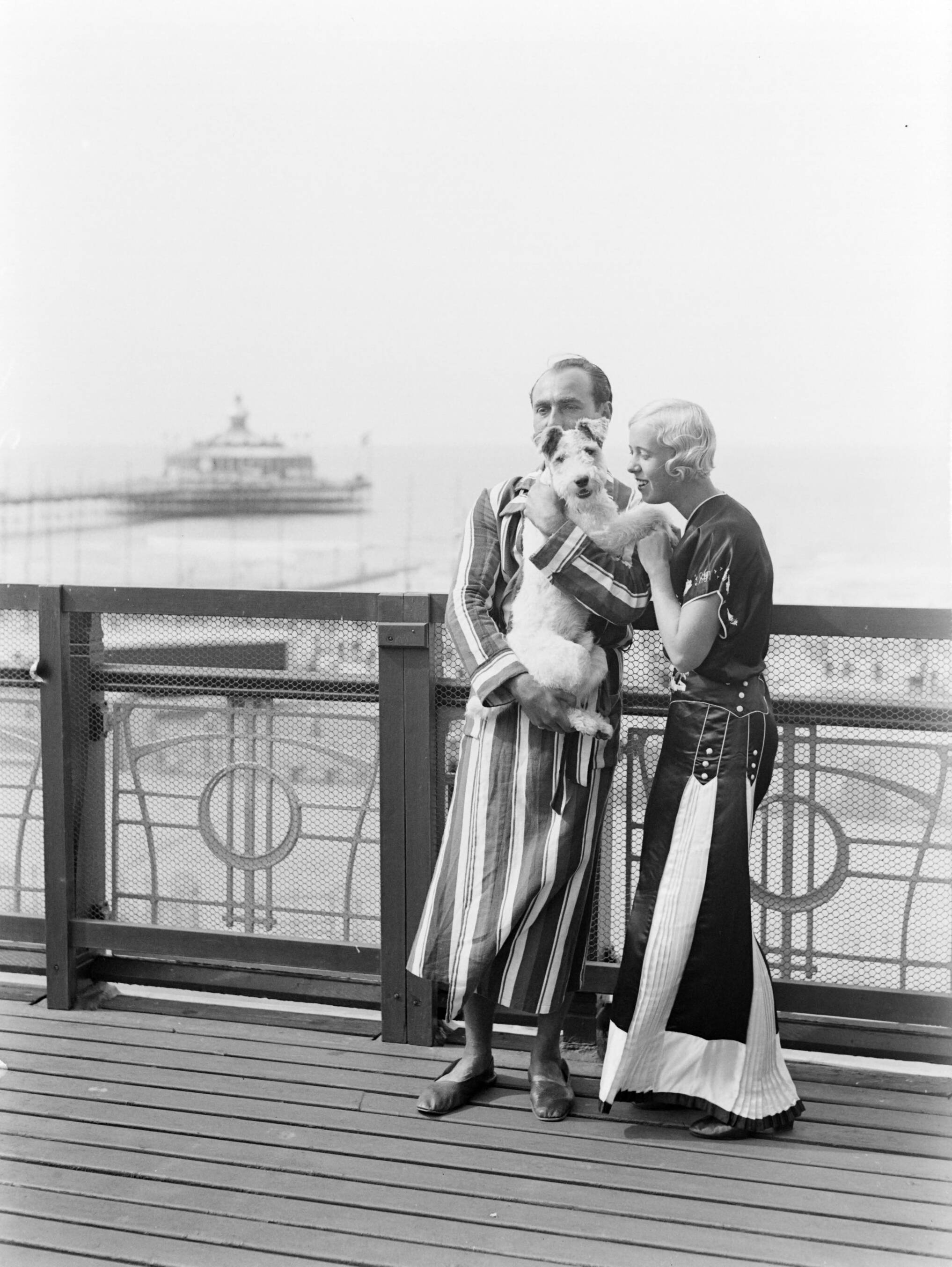 Scheveningen. — Een man (Farrar?) en een vrouw (Yvonne?) met een hond op het balkon van een hotelkamer van het Palace Hotel in Scheveningen — Foto: Poll, Willem van de. Licentie: Set B: Rechtenvrij / Publiek Domein. Bron: Nationaal Archief. http://hdl.handle.net/10648/ae9ab77e-d0b4-102d-bcf8-003048976d84