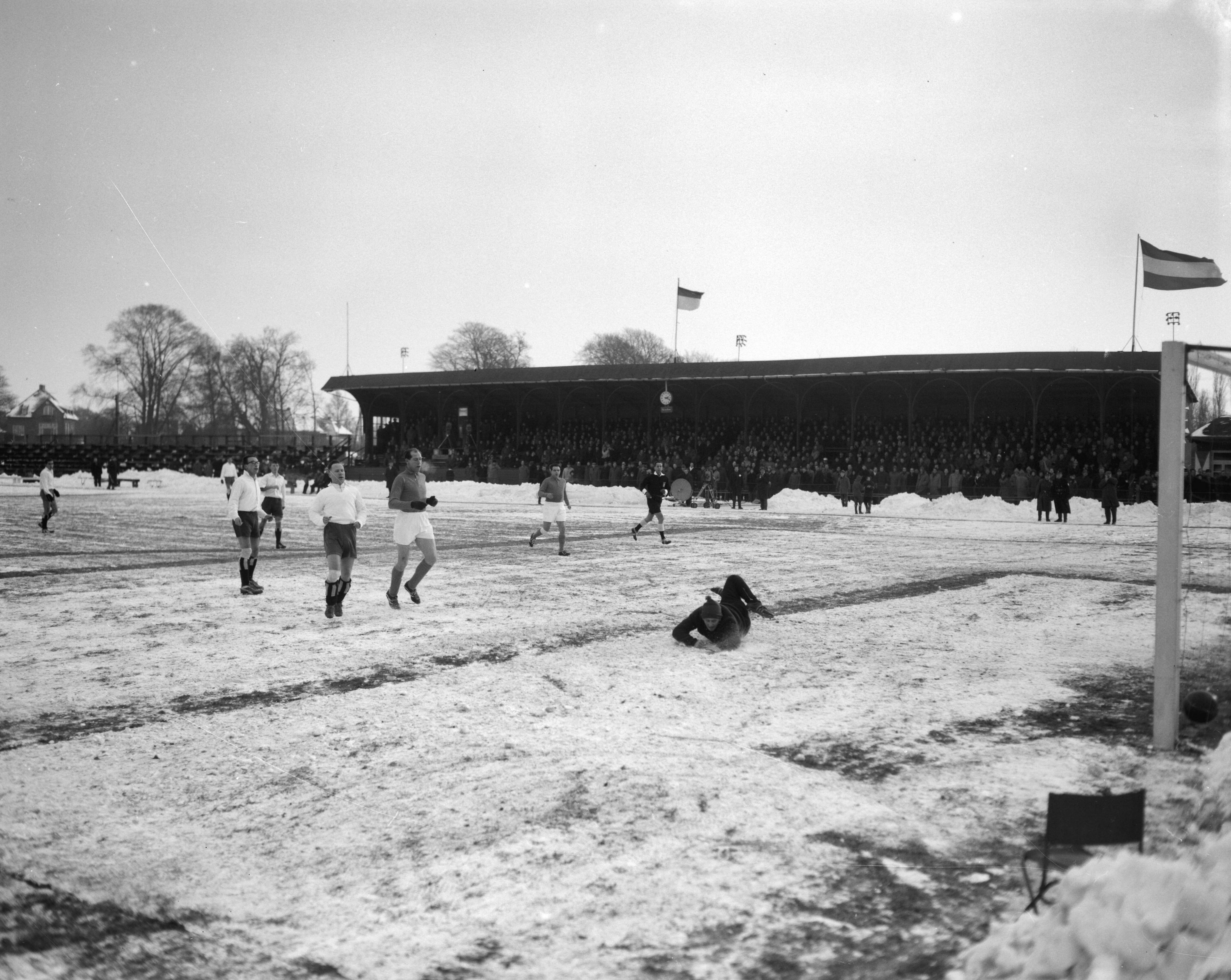 Fotocollectie Anefo — Traditionele nieuwjaars voetbalwedstrijd tussen de Koninklijke HFC en Oud-Internationals 2-8. Spelmoment voor het HFC-doel, in het midden Wout Heinen, rechts Guus Dräger, op de grond HFC-keeper Guus van der Meulen jr. — Foto: Bilsen, Joop van / Anefo. Licentie: Set B: Rechtenvrij / Publiek Domein. Bron: Nationaal Archief. http://hdl.handle.net/10648/aa246500-d0b4-102d-bcf8-003048976d84