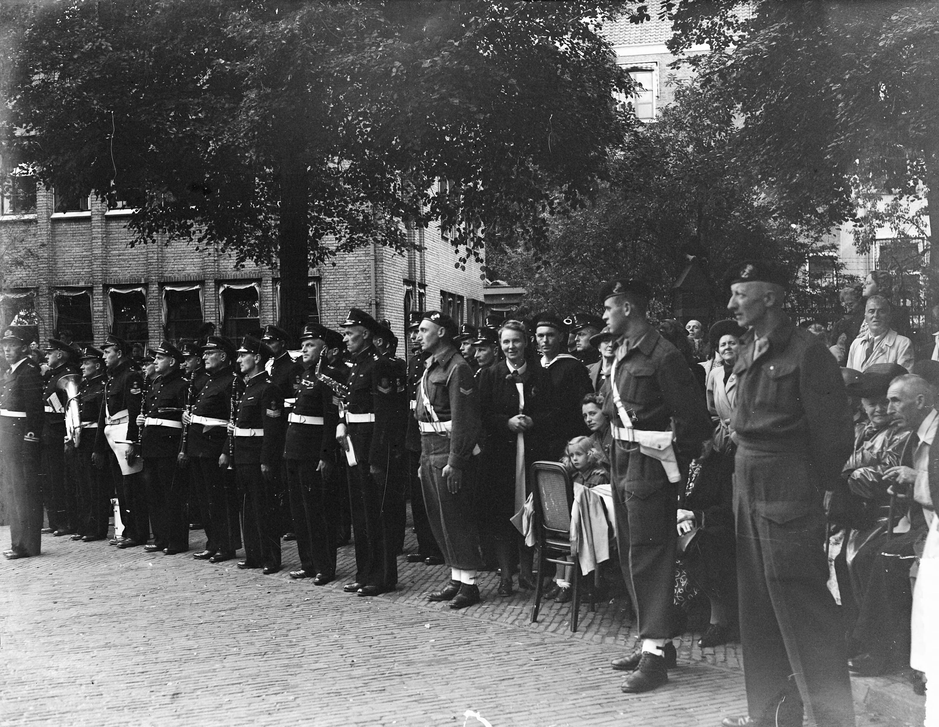 Intocht van koningin Juliana in Den Haag (1948) — Intocht Koningin Juliana in Den Haag. Afzetting door drie mariners, links de Marinierskapel — Foto: Steenkamp, […] / Anefo. Licentie: Set B: Rechtenvrij / Publiek Domein. Bron: Nationaal Archief. http://hdl.handle.net/10648/a8bd3d0e-d0b4-102d-bcf8-003048976d84
