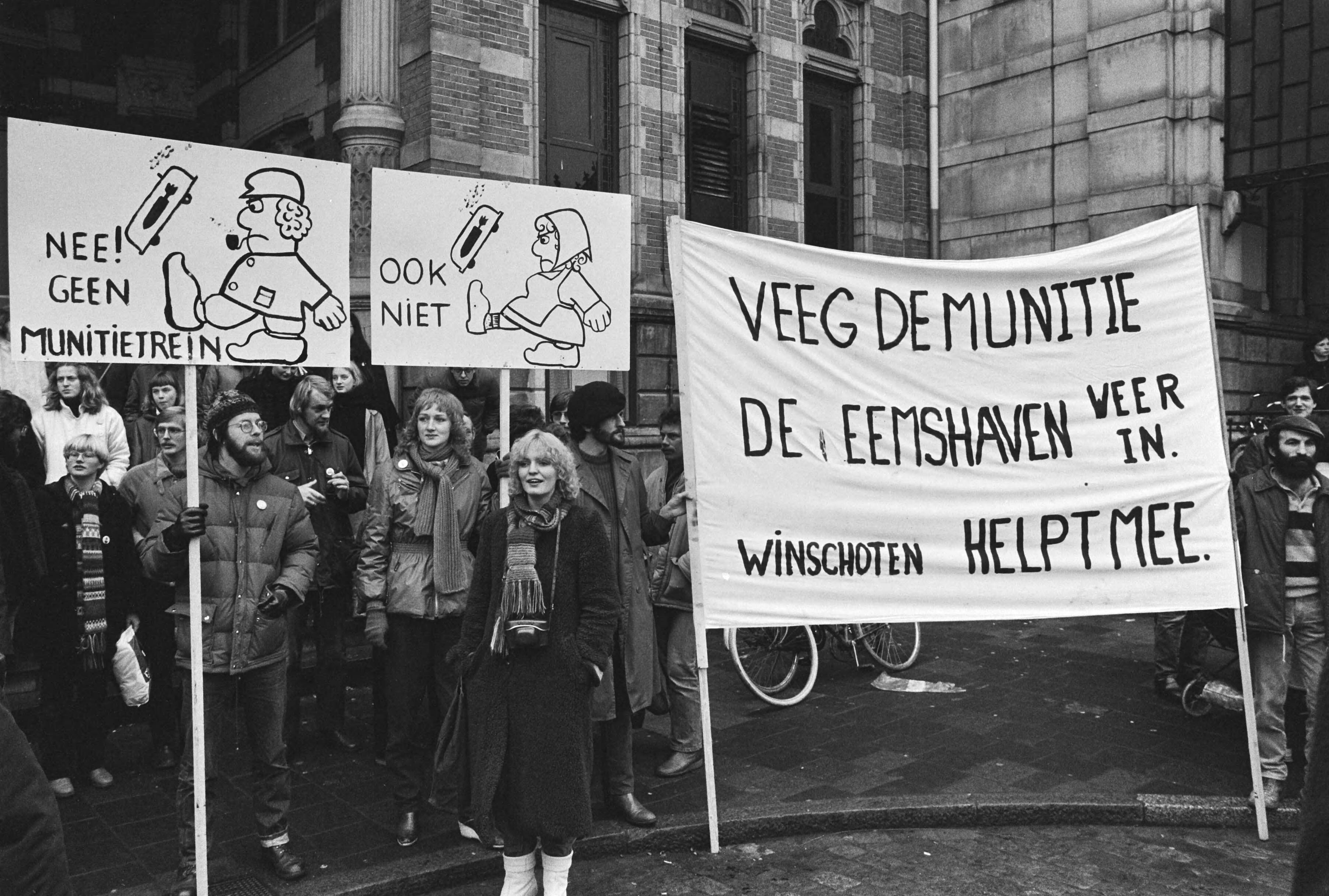 Fotocollectie Anefo — Dem. in Groningen tegen munitietransporten met treinen van de Eemshaven naar West-Duitsland. Dem. met diverse spandoeken — Foto: Bogaerts, Rob / Anefo. Licentie: Set B: Rechtenvrij / Publiek Domein. Bron: Nationaal Archief. http://hdl.handle.net/10648/ad0dfa24-d0b4-102d-bcf8-003048976d84