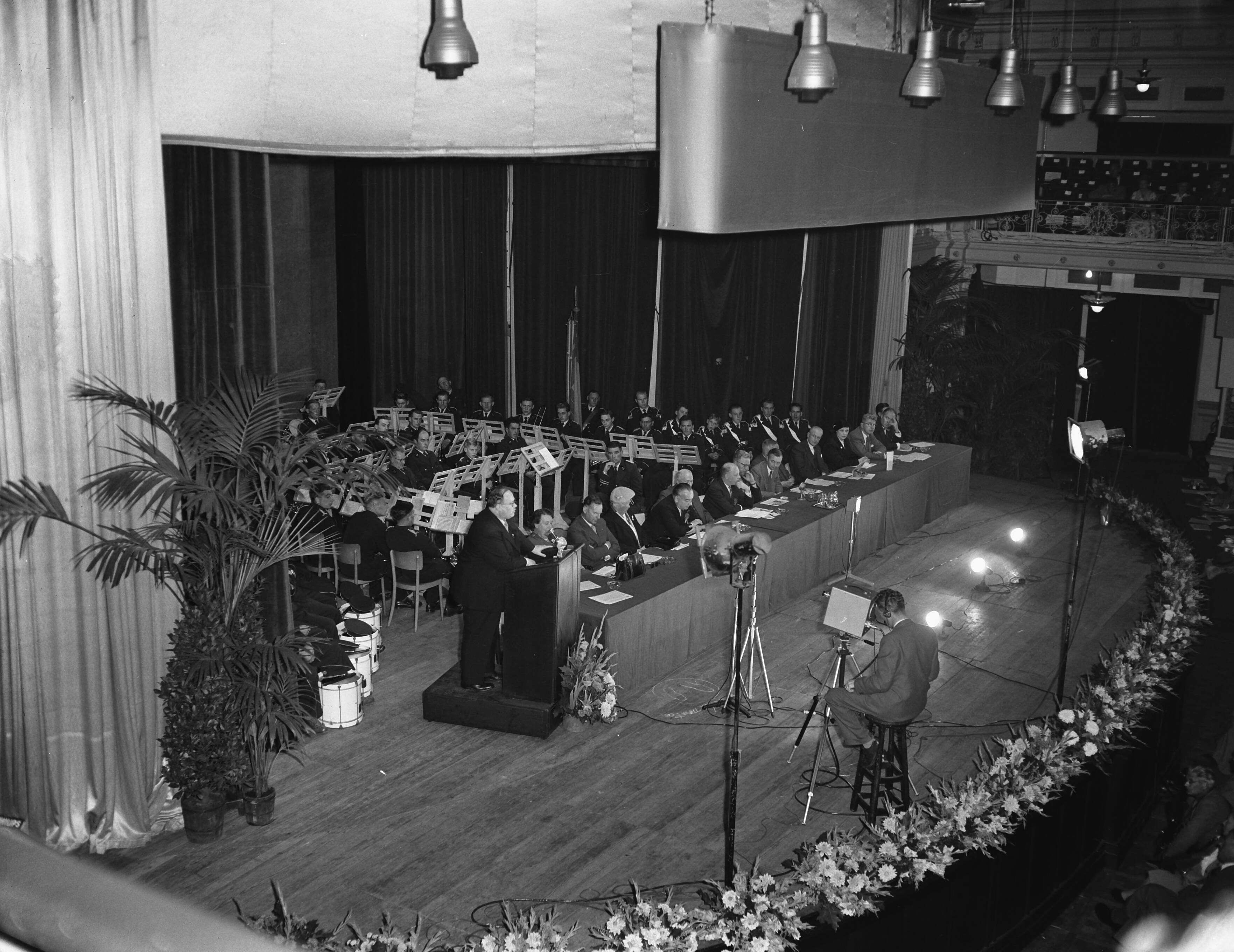 Fotocollectie Anefo — VVD-dag te Scheveningen. Redevoering van vice-voorzitter mr. H. van Riel. Voor hem een televisiecameraman — Foto: Pot, Harry / Anefo. Licentie: Set B: Rechtenvrij / Publiek Domein. Bron: Nationaal Archief. http://hdl.handle.net/10648/a93b1c06-d0b4-102d-bcf8-003048976d84