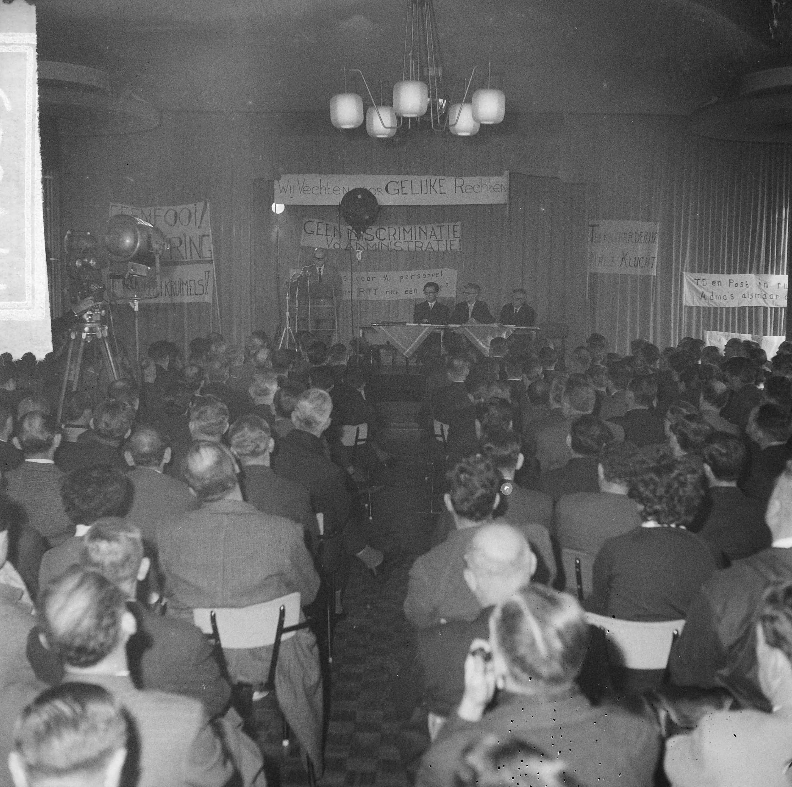 Fotocollectie Anefo — 500 PTT-ers protesteren tegen personeels- en promotiebeleid bij PTT in het Houtrustrestaurant te Den Haag — Foto: Gelderen, Hugo van / Anefo. Licentie: Set B: Rechtenvrij / Publiek Domein. Bron: Nationaal Archief. http://hdl.handle.net/10648/aa821b1e-d0b4-102d-bcf8-003048976d84