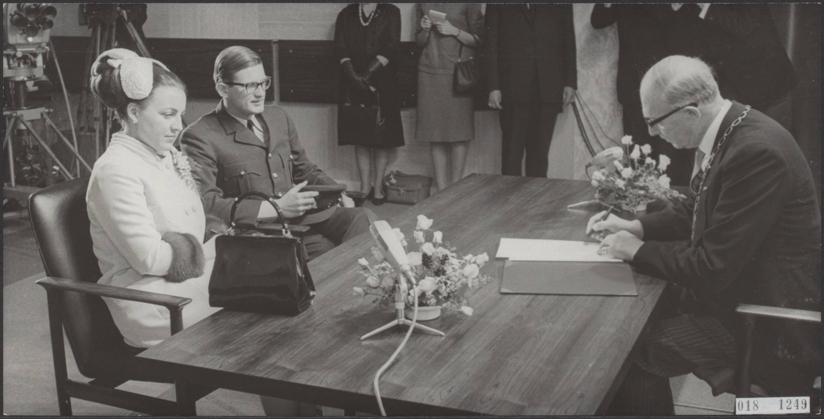 Fotocollectie Elsevier Binnenland — In het Baarnse stadhuis zijn prinses Margriet en mr. Pieter van Vollenhoven ondertrouwd. Het jonge paar voor de tafel, waarachter de burgemeester mr. F.J. van Beeck Calkoen — Foto: Koch, Eric / Anefo. Licentie: Set B: Rechtenvrij / Publiek Domein. Bron: Nationaal Archief. http://hdl.handle.net/10648/adc4bcdc-d0b4-102d-bcf8-003048976d84