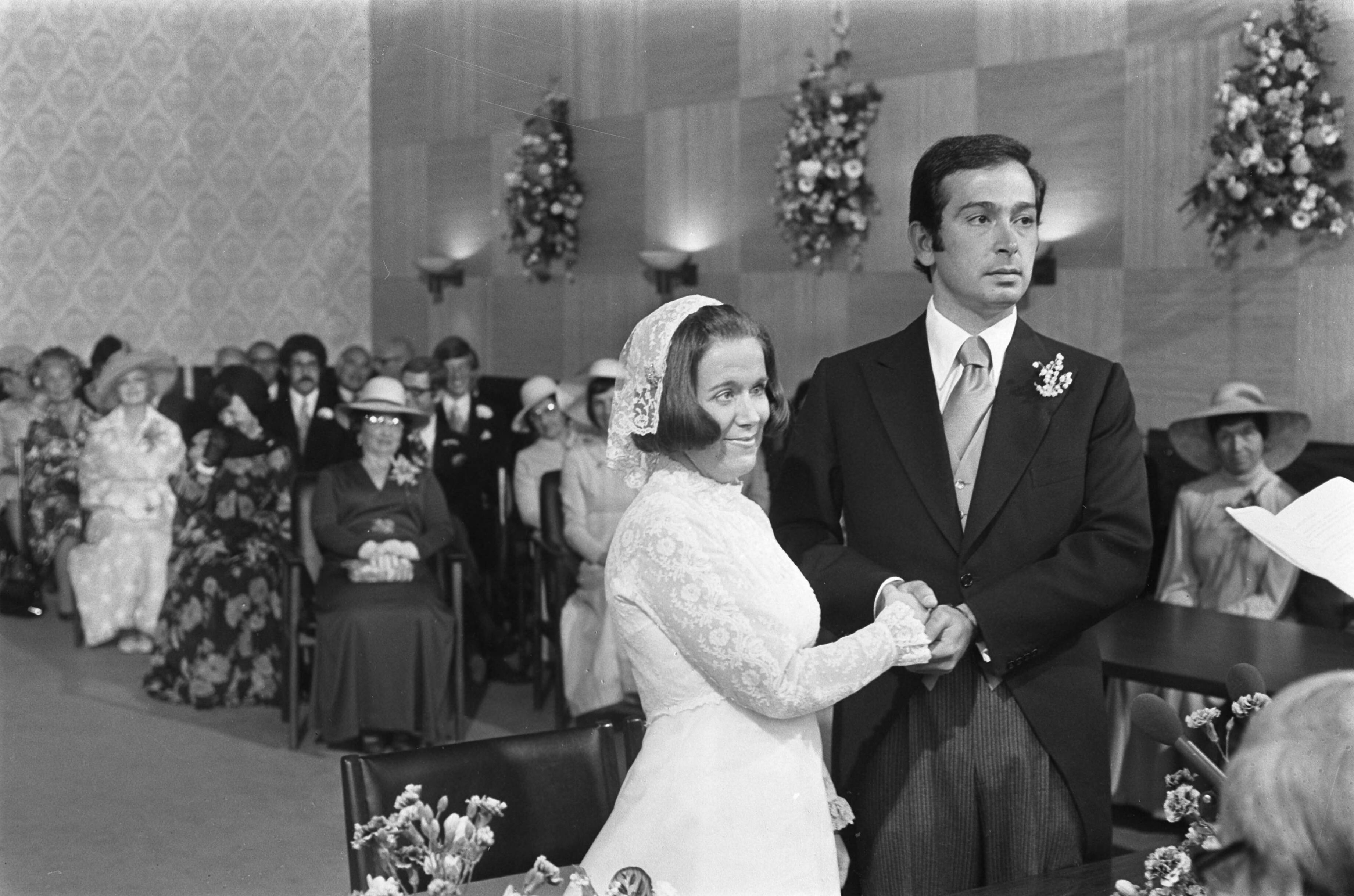Huwelijk prinses Christina en Jorge Guillermo; de sluiting van het burgerlijk huwelijk in het stadhuis van Baarn — Prinses Christina en Jorge Guillermo staan voor de burgemeester bij de sluiting van het burgerlijk huwelijk — Foto: Meerdere fotografen / Anefo. Licentie: Set B: Rechtenvrij / Publiek Domein. Bron: Nationaal Archief. http://hdl.handle.net/10648/ac6c5890-d0b4-102d-bcf8-003048976d84