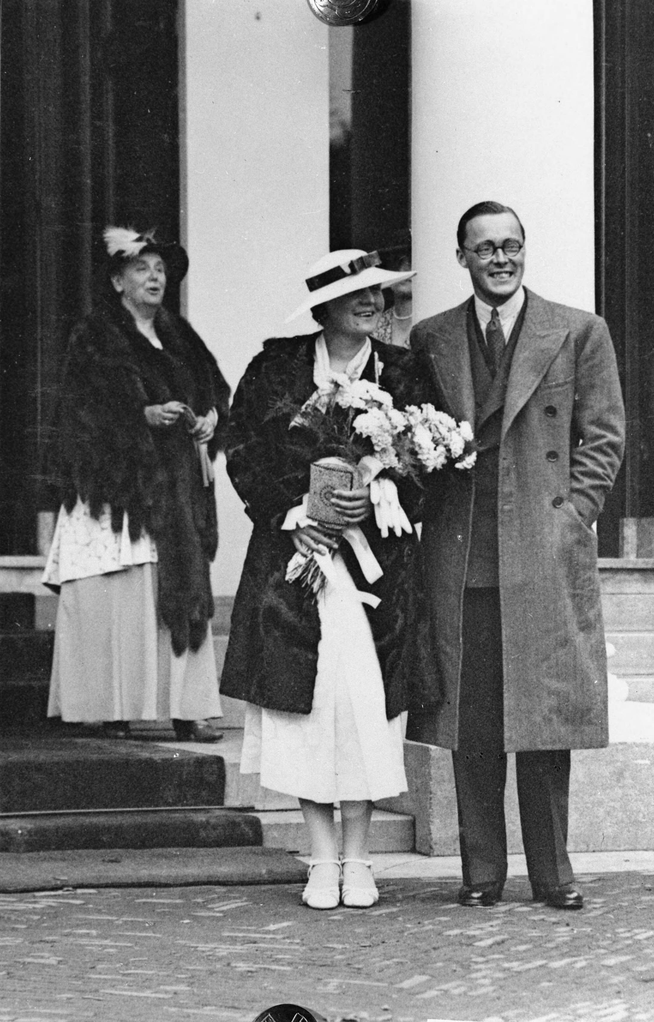 Fotocollectie RVD / Koninklijk Huis — Prinses Juliana met prins Bernhard als verloofd paar. Aankomst paleis Noordeinde te Den Haag,dinsdag 8 september 1936. Op de achtergrond koningin Wilhelmia — Foto: Rousel (repro) / RVD. Licentie: Set B: Rechtenvrij / Publiek Domein. Bron: Nationaal Archief. http://hdl.handle.net/10648/afb5e76e-d0b4-102d-bcf8-003048976d84