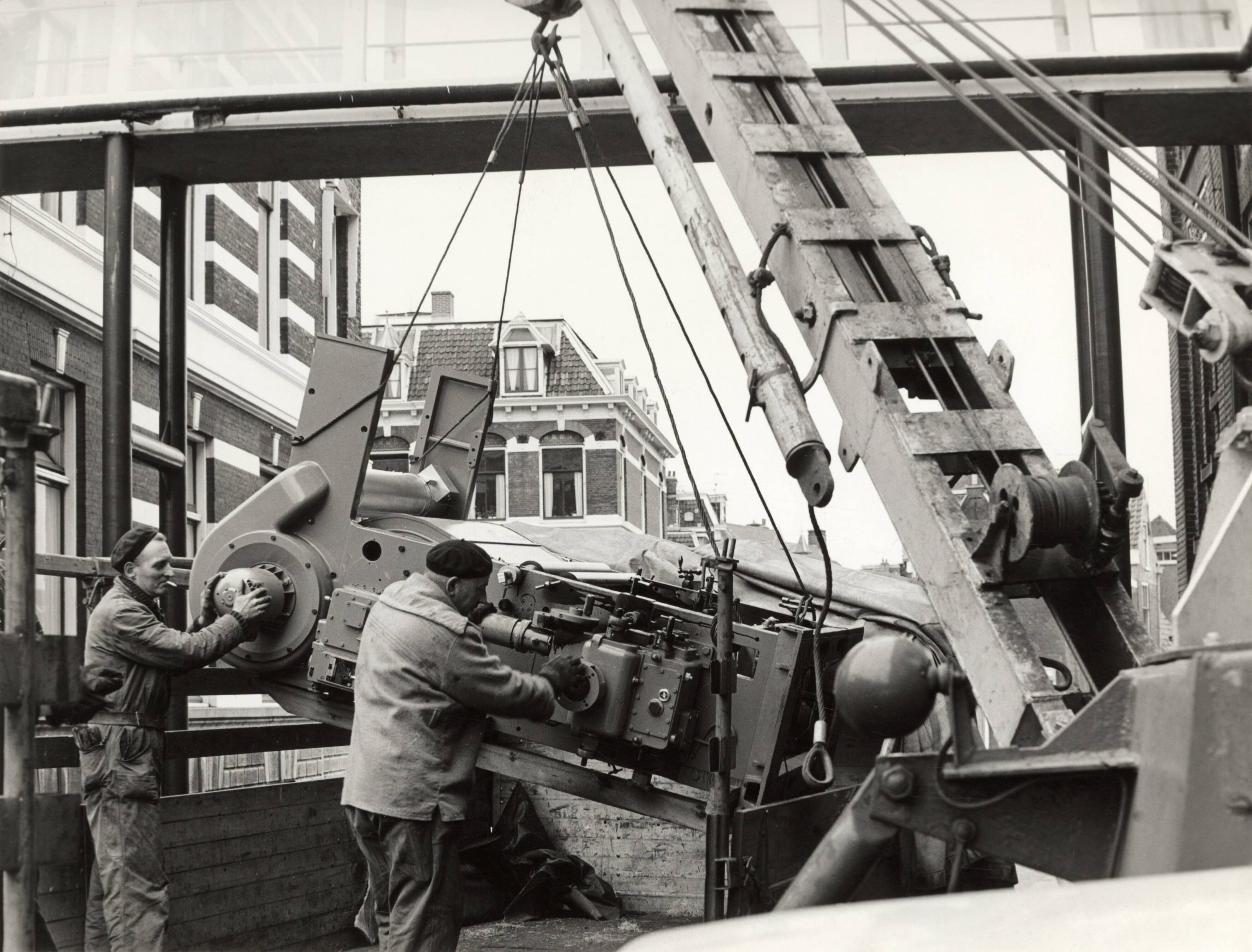 Drukkerij Spaarnestad — [Een drukpers wordt de drukkerij van Spaarnestad te Haarlem ingehesen] — Foto: Fotograaf Onbekend / Fotobureau onbekend / Spaarnestad Photo (05887). Licentie: Set B: Rechtenvrij / Publiek Domein. Bron: Nationaal Archief. http://hdl.handle.net/10648/35429da6-399b-a382-e063-6df0900a6686